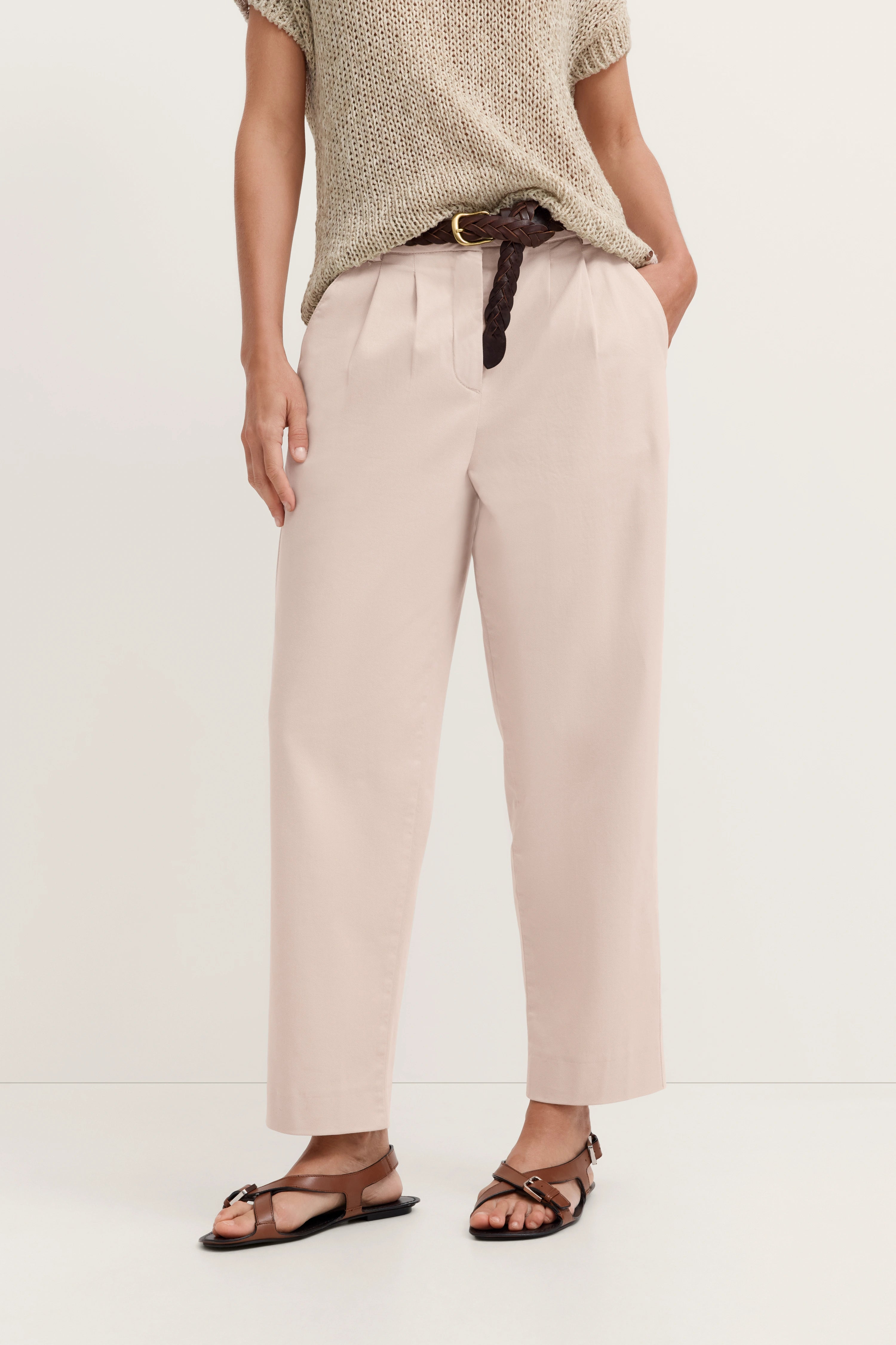 Beiger Strickpullover, cremefarbene Hose, brauner Gürtel, Sandalen