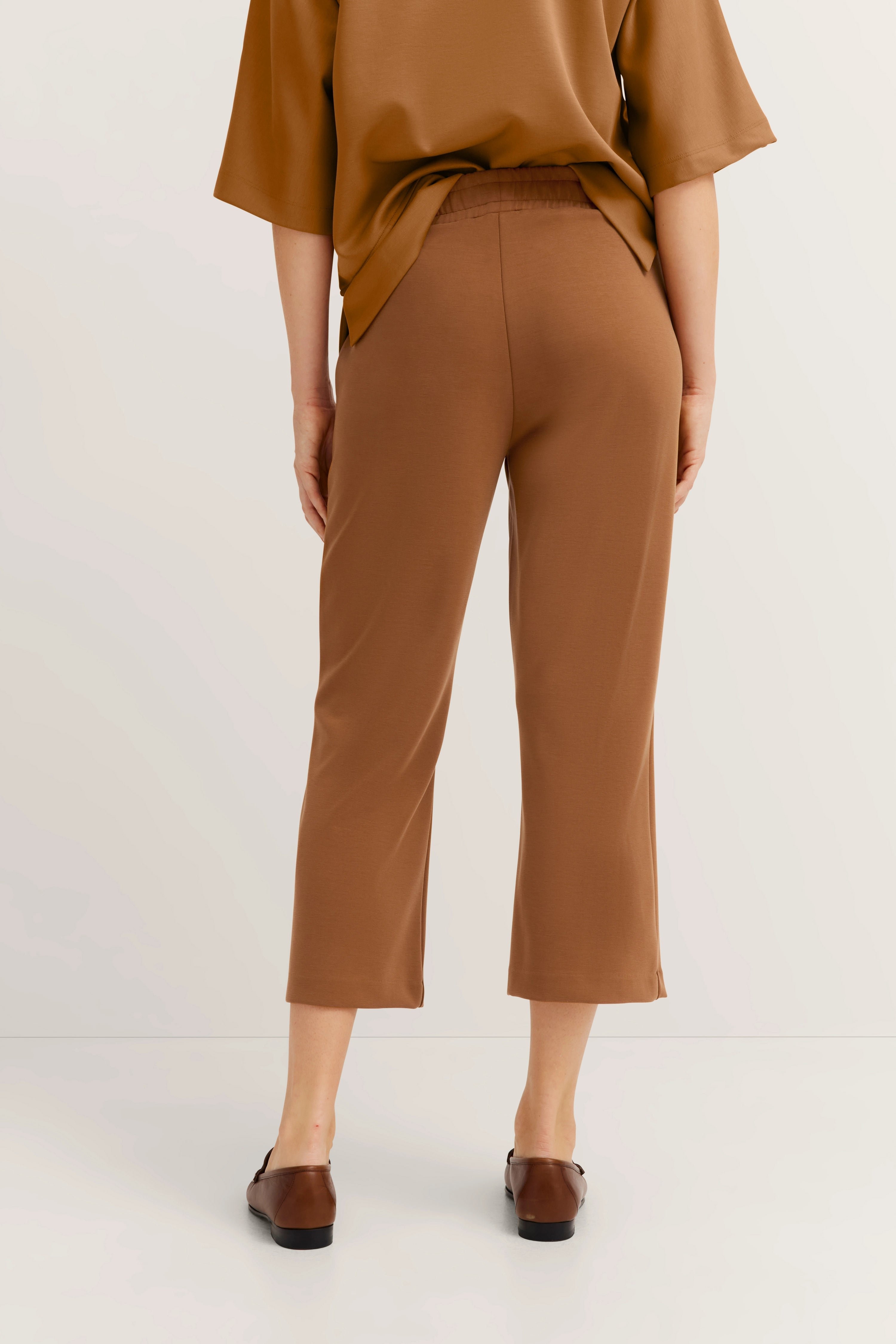 Bruin ensemble met wijde broek en los topje, achterkant, casual modelbeeld, casual look.