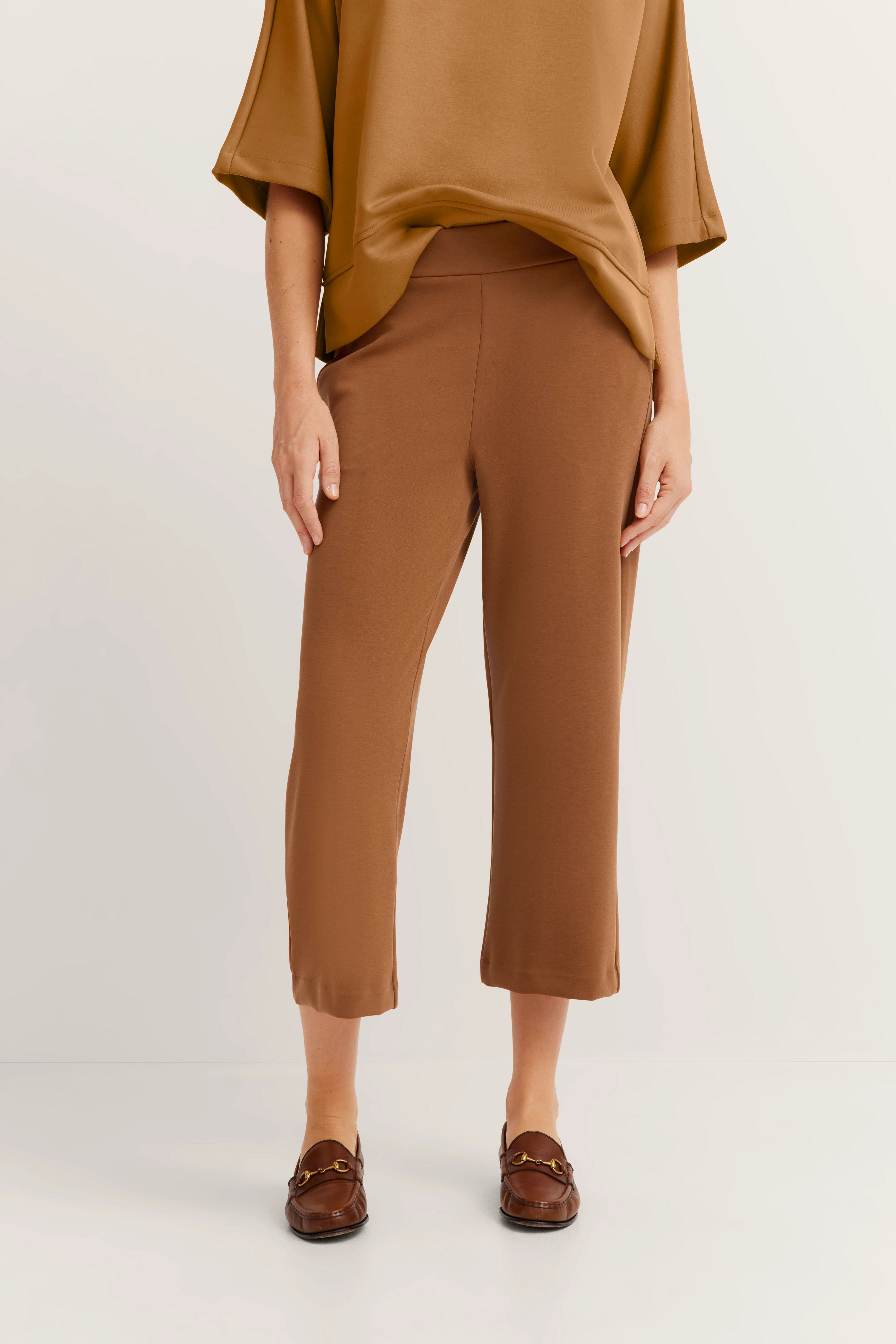 Bruin bugatti outfit, casual modelbeeld, ontspannen houding, vloeiende blouse, enkel-lange broek.