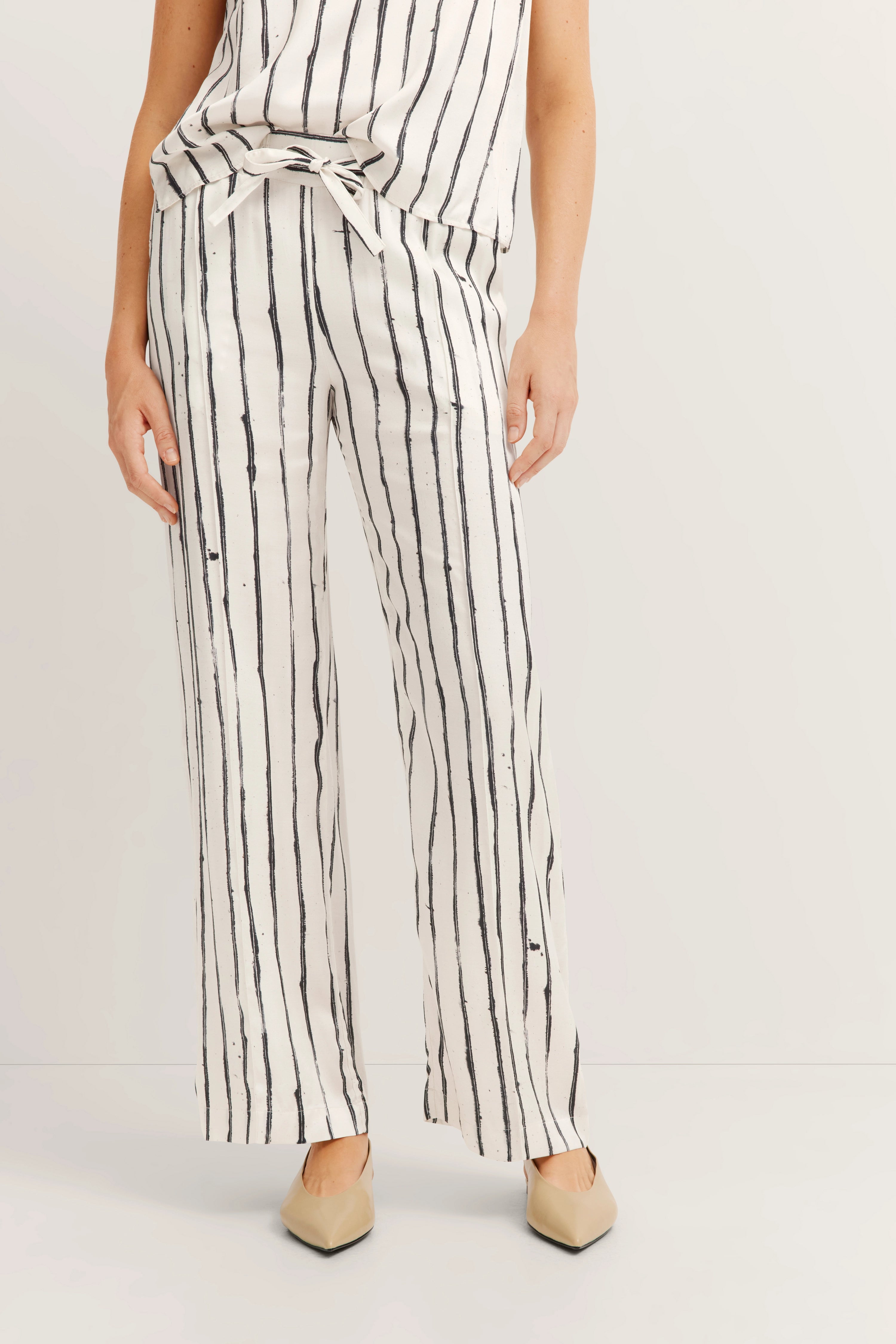 Stripe outfit in white and black, casual model image, relaxed pose.