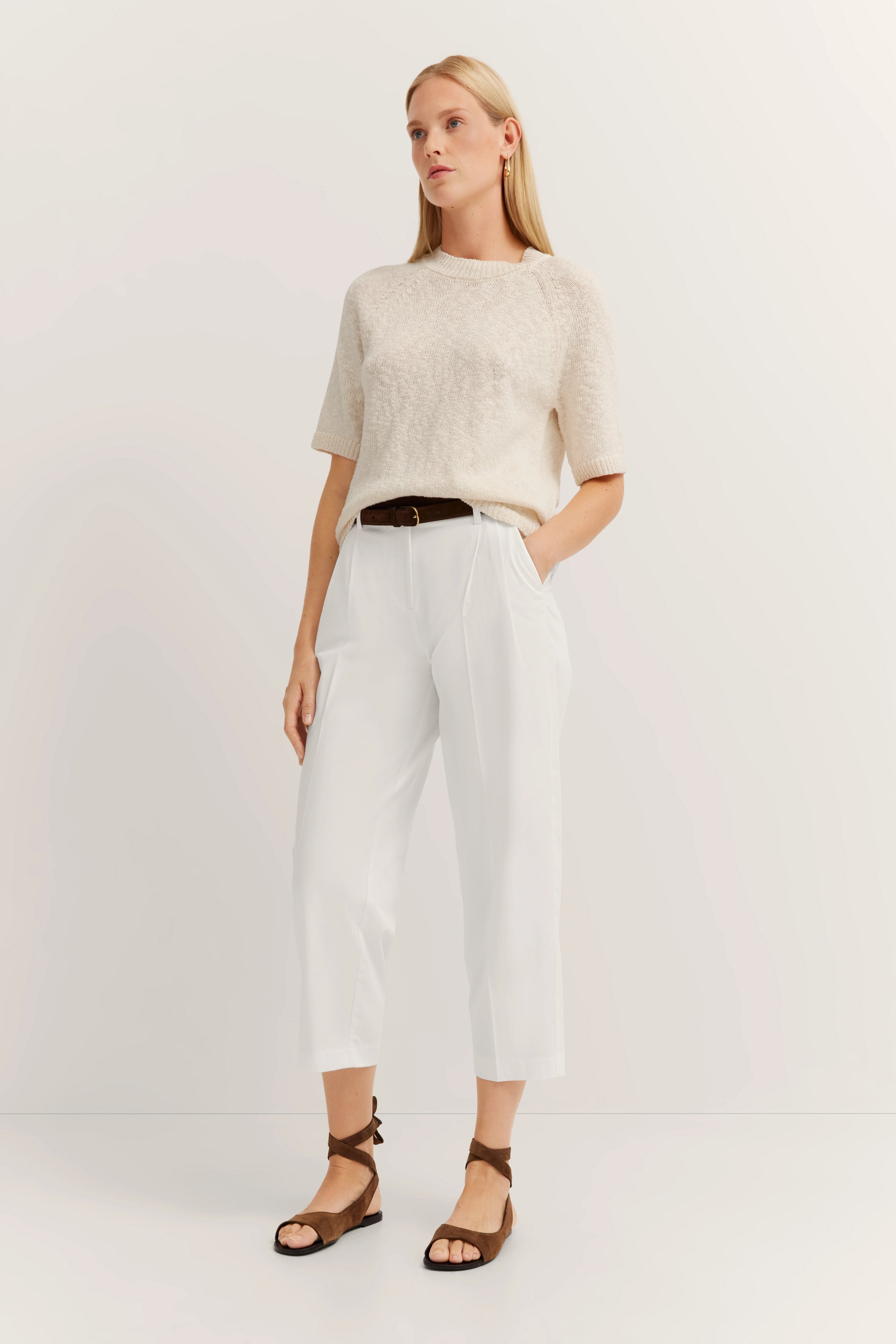 Beige trui, witte broek, bruine sandalen van bugatti, geïnspireerd door Italiaanse elegantie en tijdloze schoonheid.