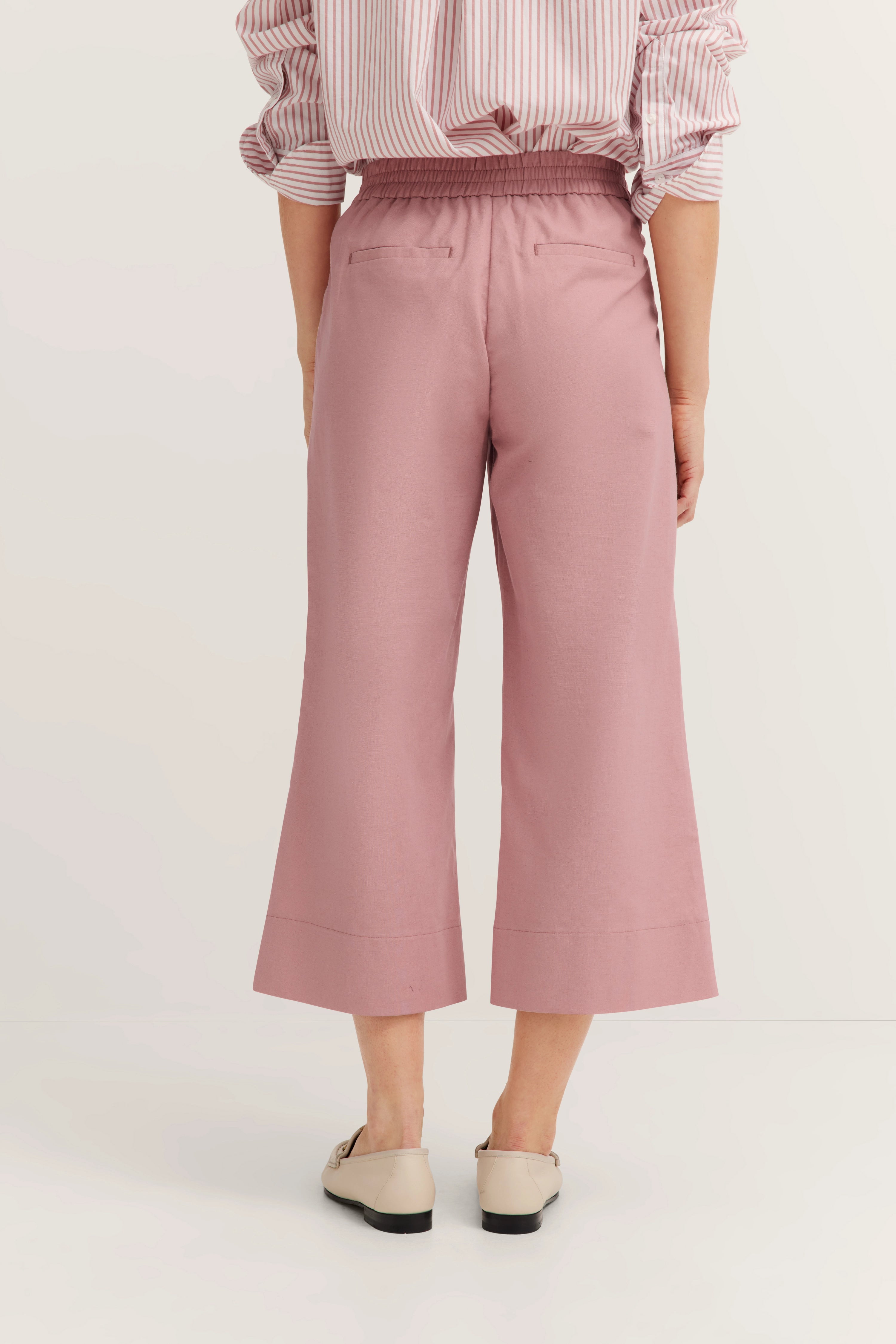 Pink culottes and striped blouse, casual model image, rear view.