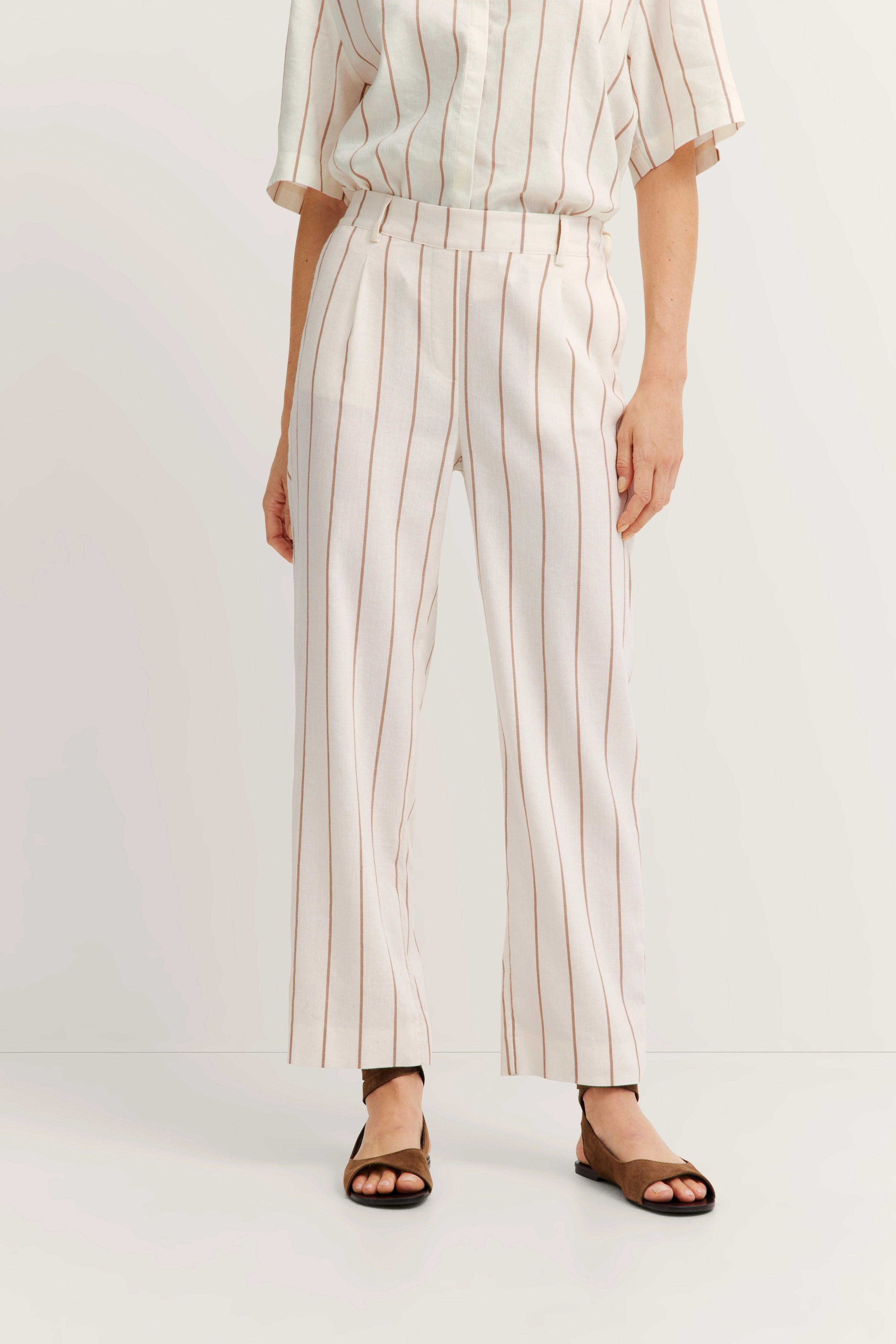 Weißes Outfit mit braunen Streifen, bestehend aus Hemd und Hose