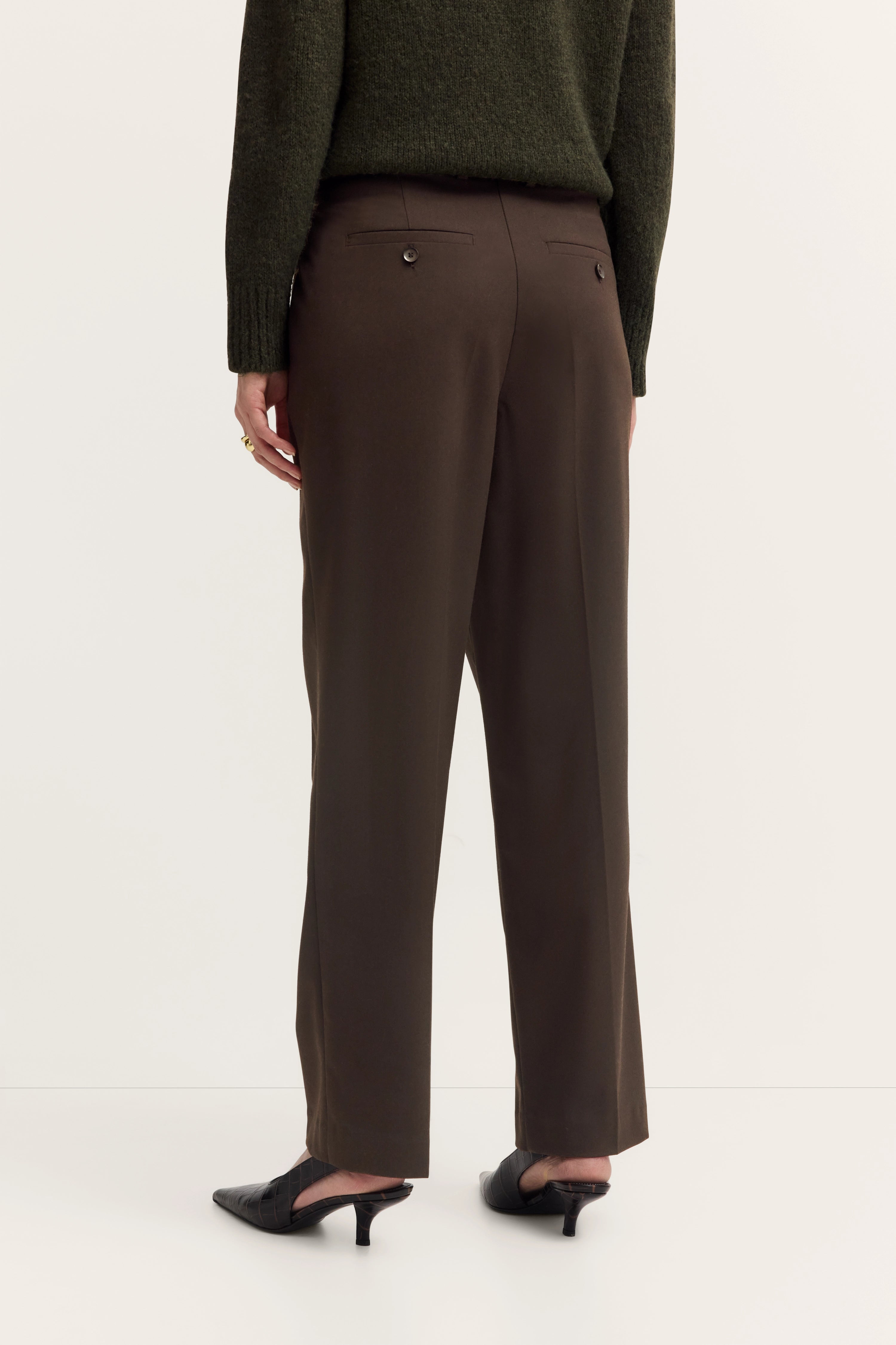 Grüner Pullover und braune Hose, Model von hinten, schwarzer Schuh, legerer Stil, bugatti.