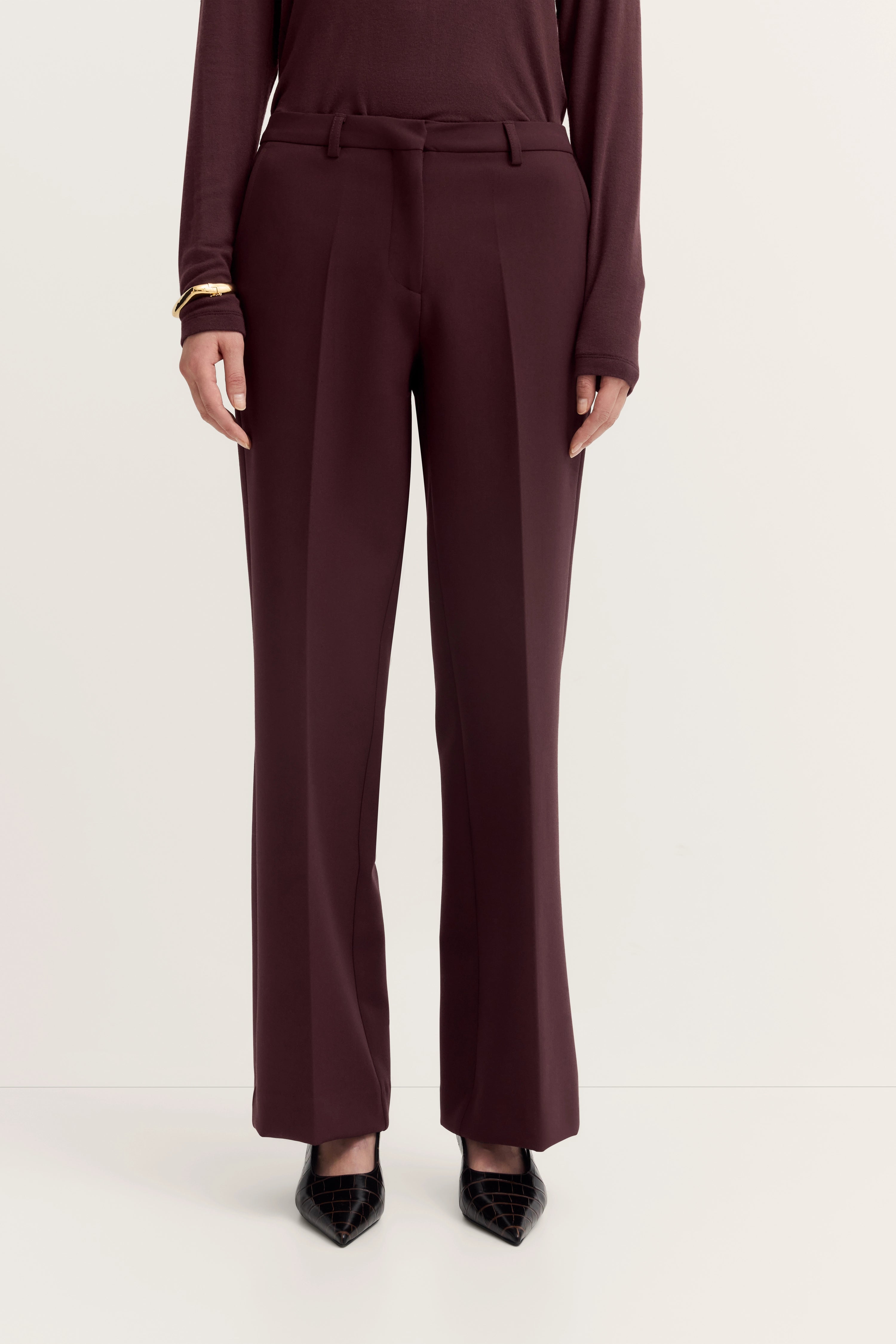 Dark red bugatti pants, casual model shot, paired with elegant black shoes.