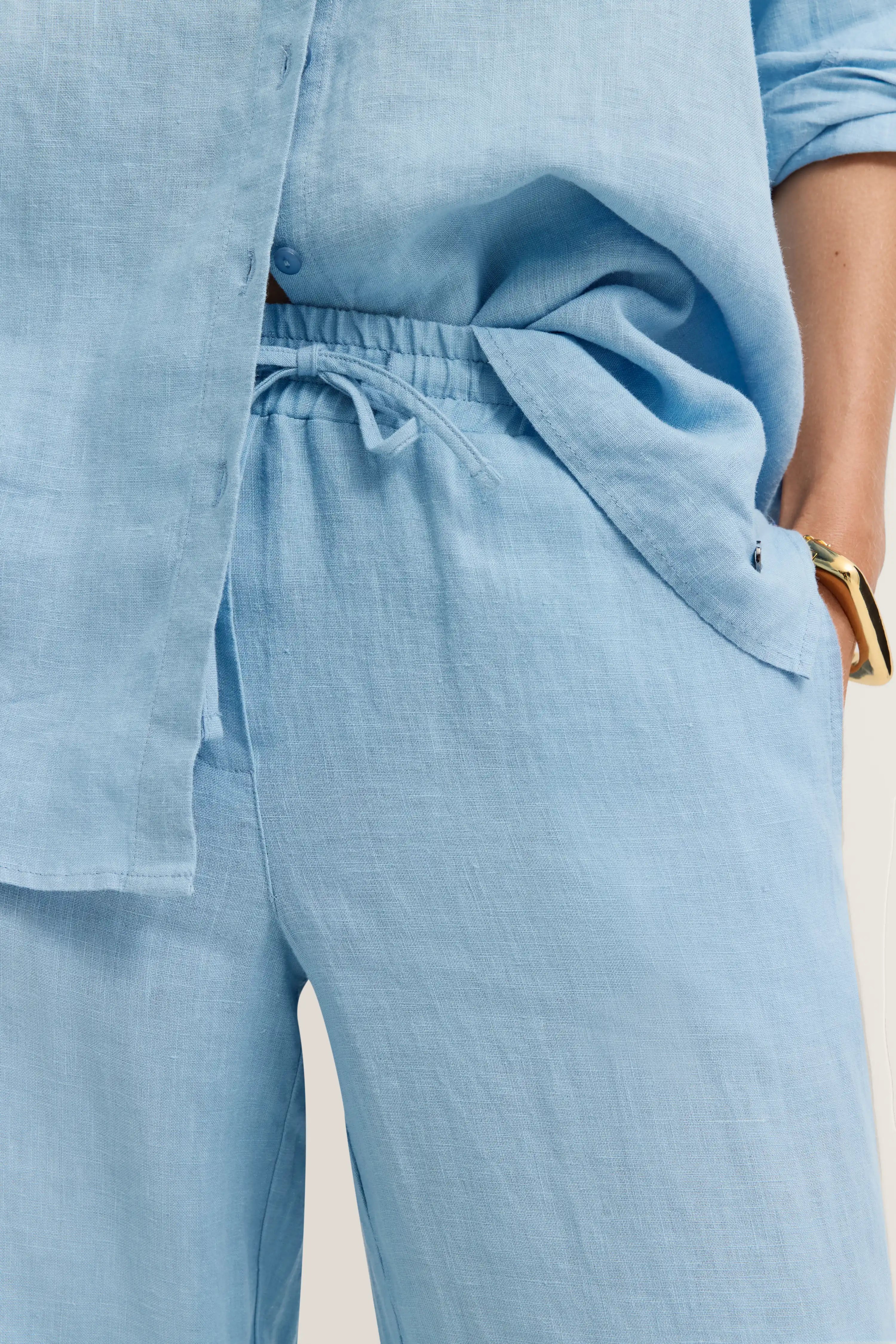 Hellblaues Leinen-Outfit mit Hemd und Hose, legeres Bild, zeigt Detailansicht der Textur.