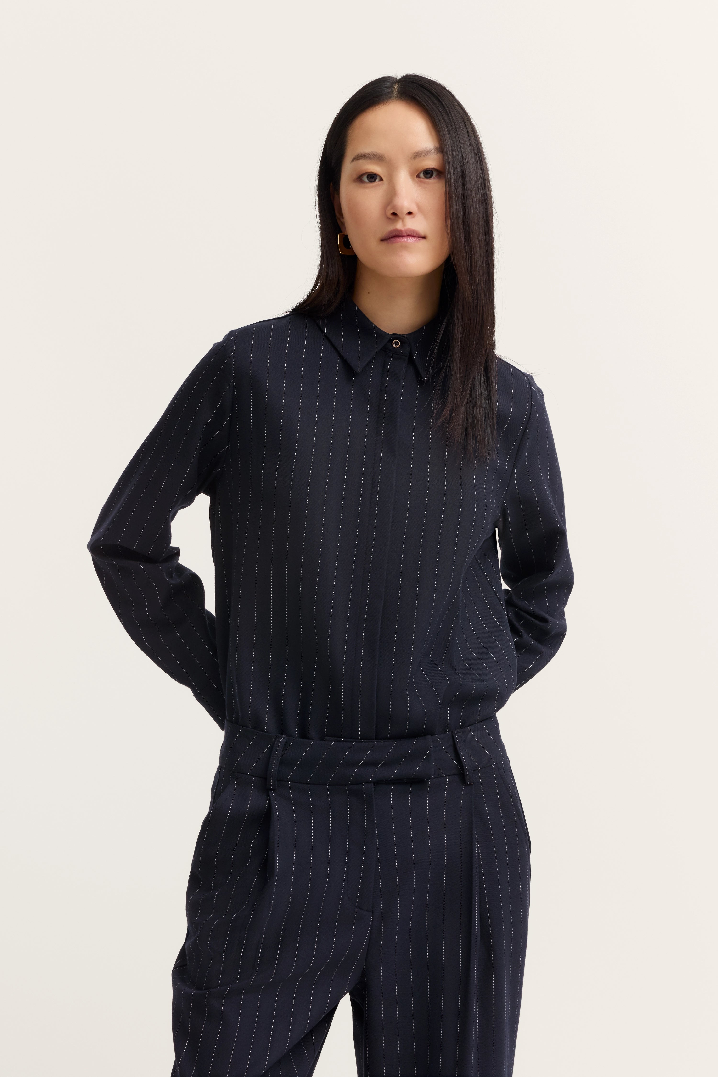 Dunkelblauer Nadelstreifenanzug, Modelbild, entspanntes Posing.