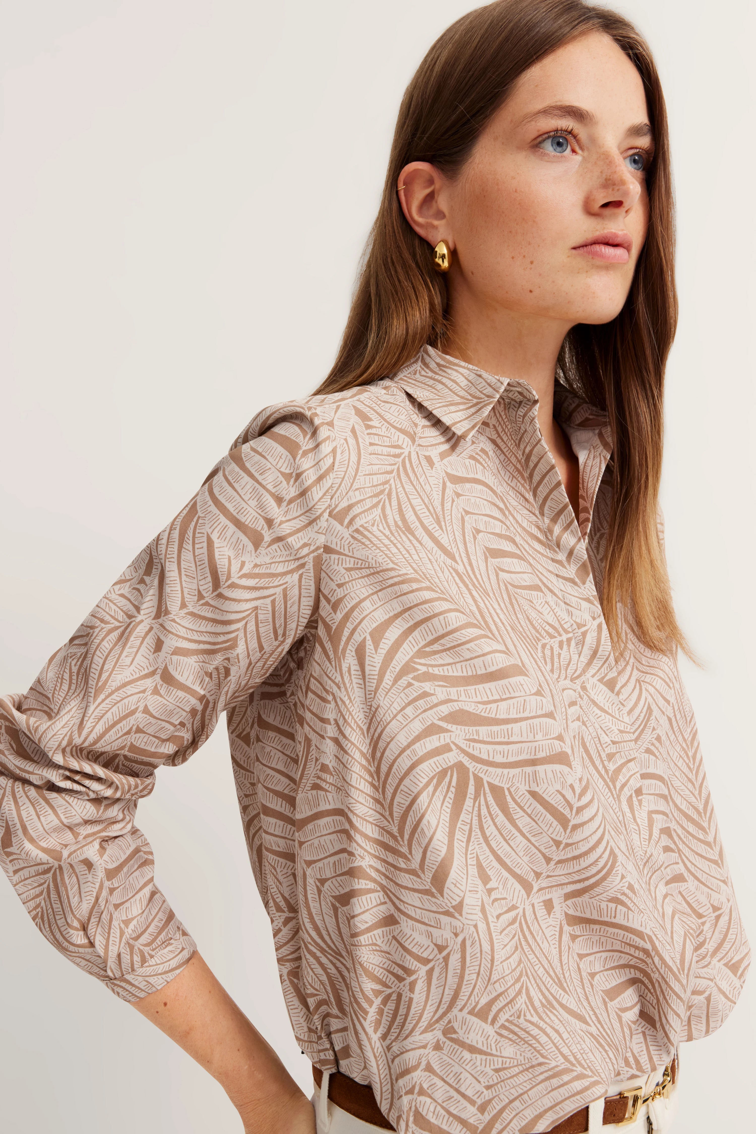 Beige gemustertes Hemd auf Model, Seitenansicht, entspannte Pose.