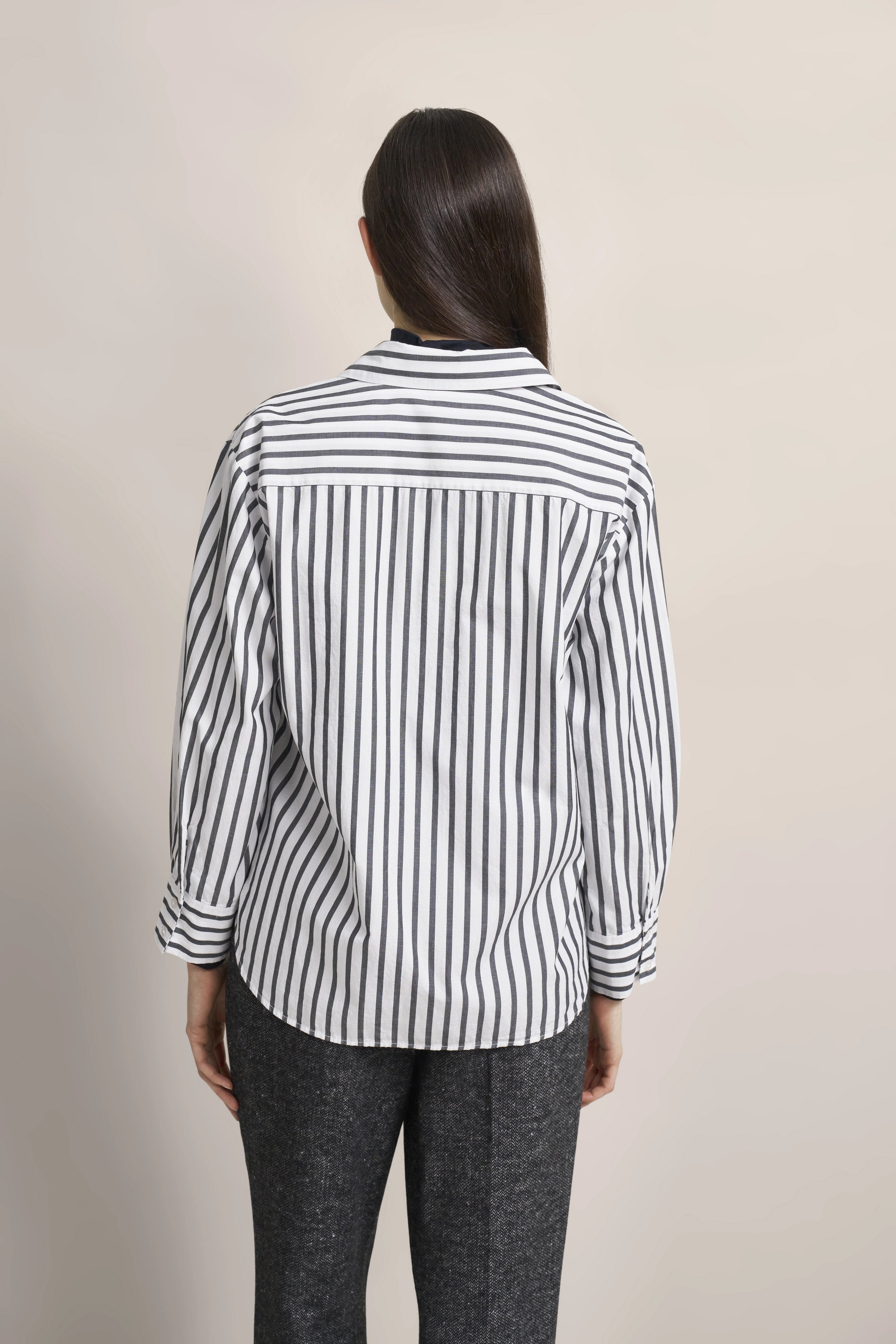 Büstenbild mit bugatti Hemd in Schwarz-Weiß gestreift, kombiniert mit grauer Hose. Elegant und stilvoll.