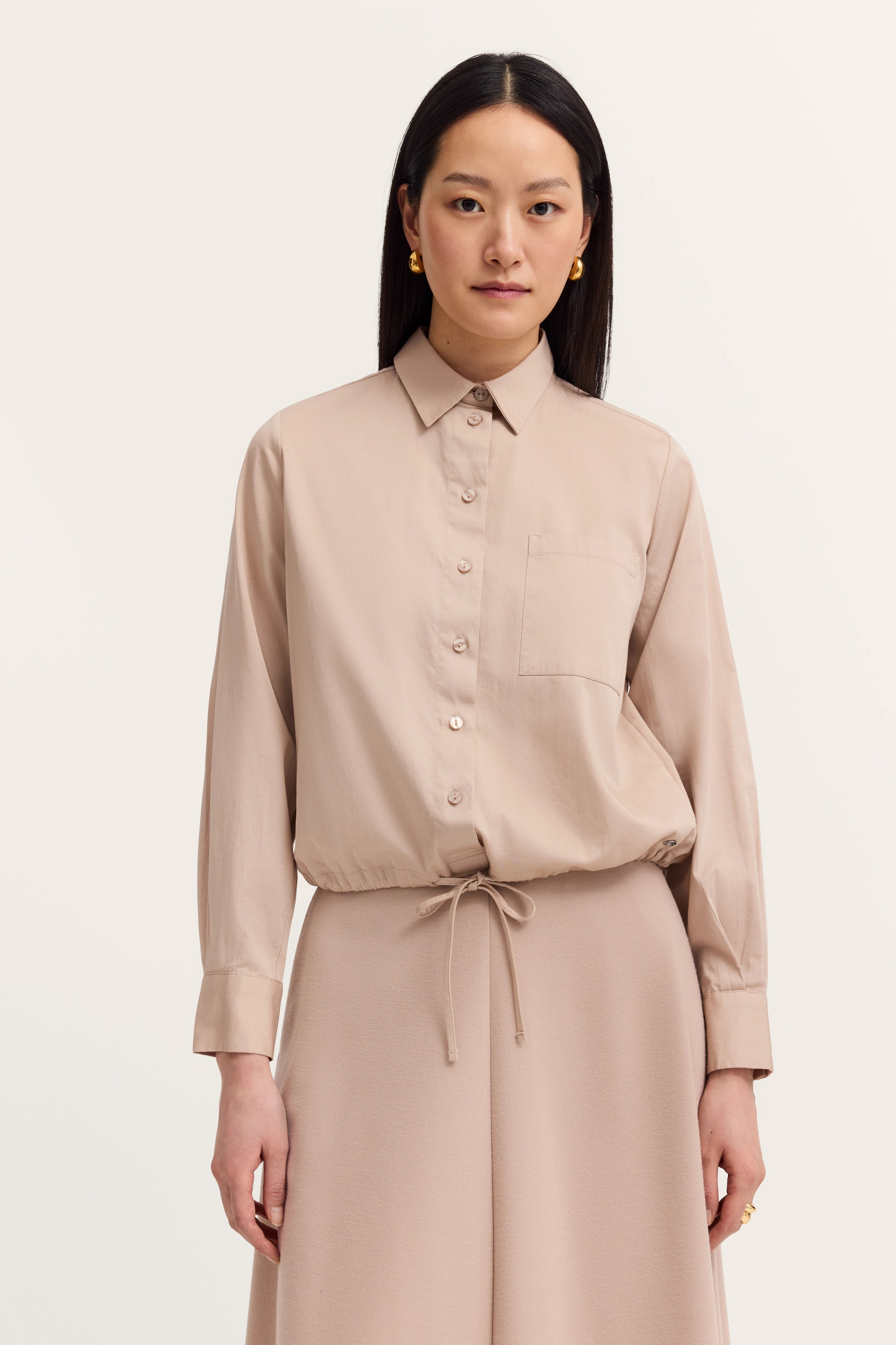 Beige bugatti outfit, collared blouse with tie, casual model pose, upright stance.