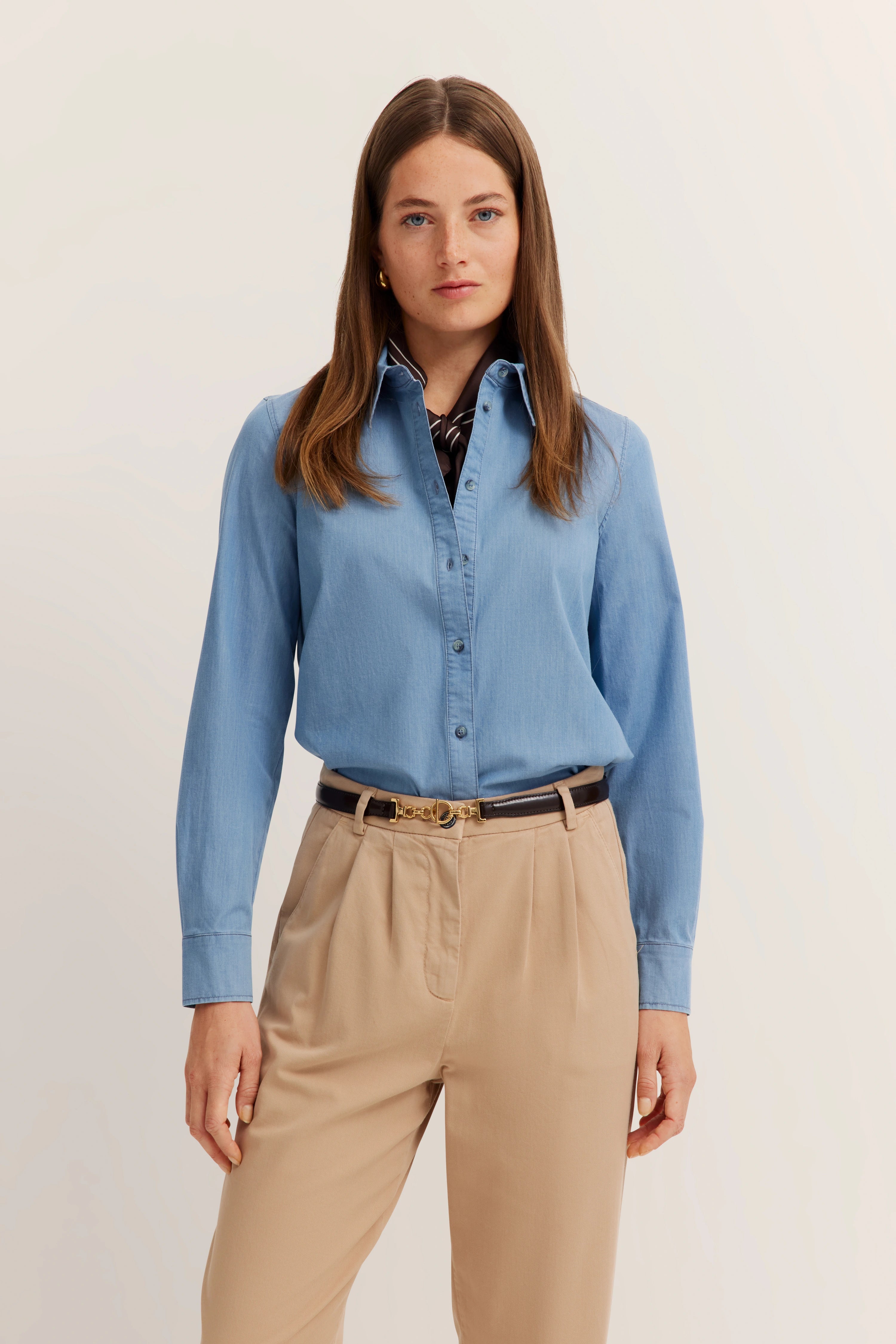 Modelbild mit blauem Hemd und beigen Hosen, entspanntes Posing, Stil von bugatti.