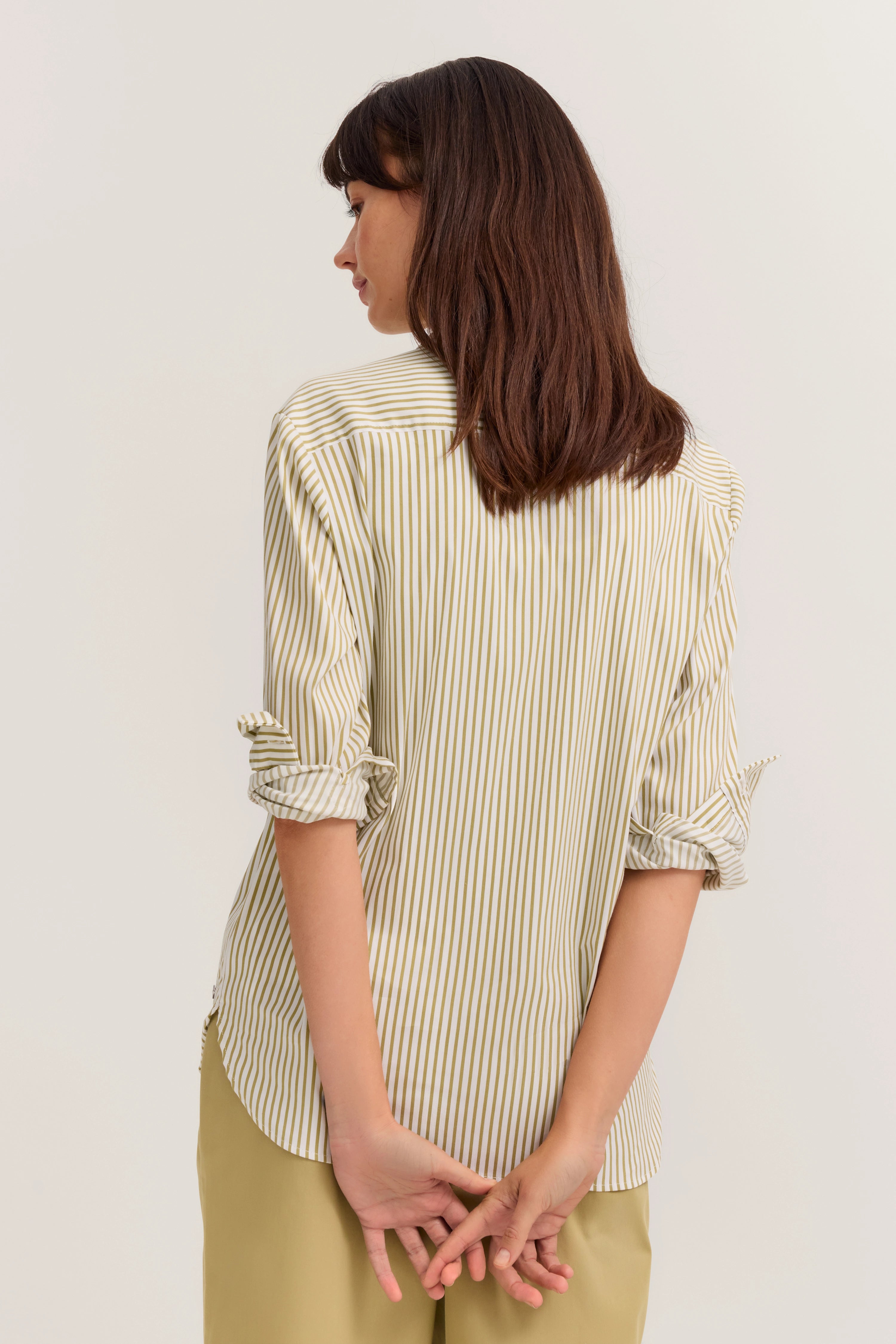 Streifenbluse in Beige und Olive mit hochgekrempelten Ärmeln, Rückenansicht, legeres Modelbild.