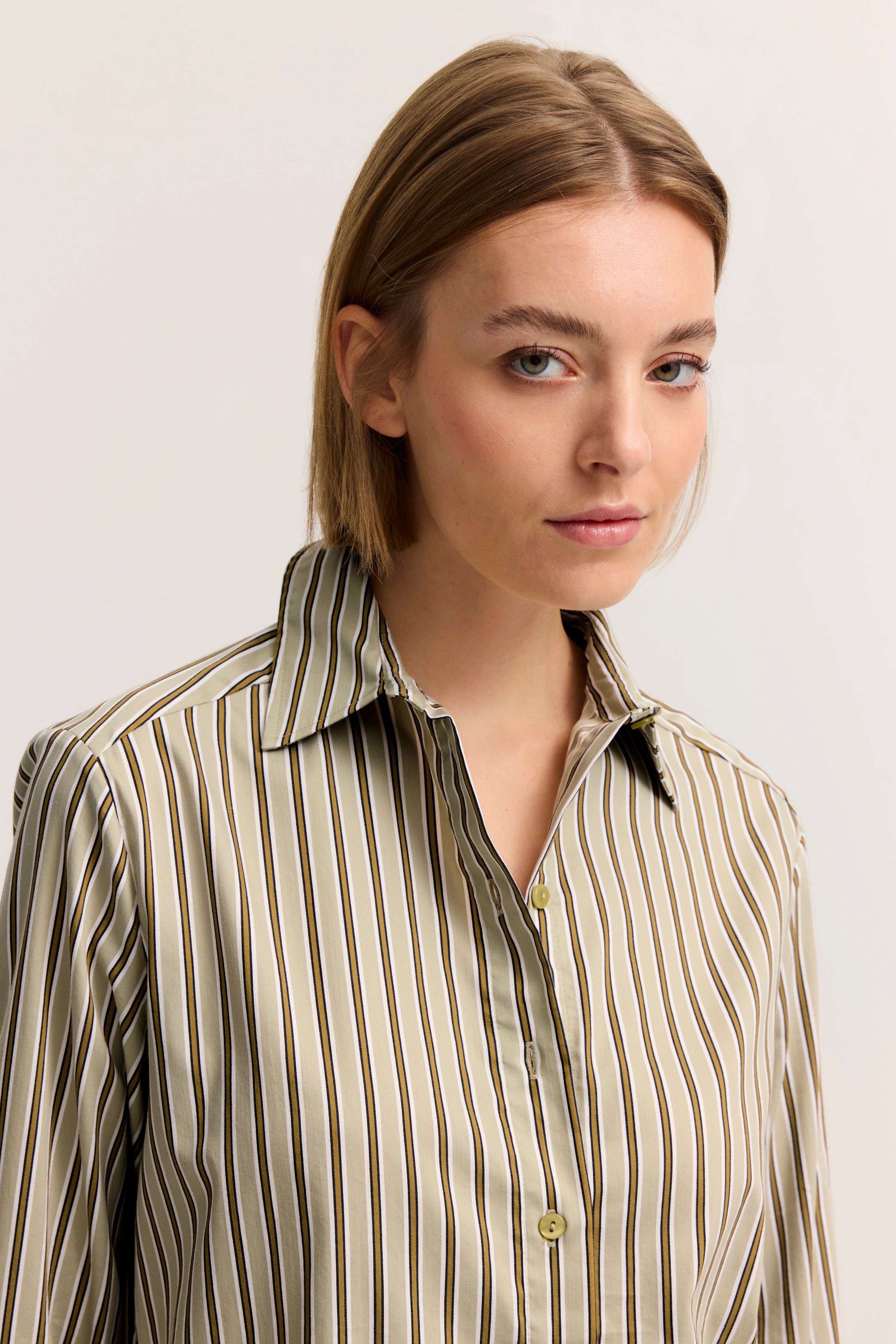 Streifenhemd in Beige mit Kragen, Modelbild, entspannter Blick zur Seite.
