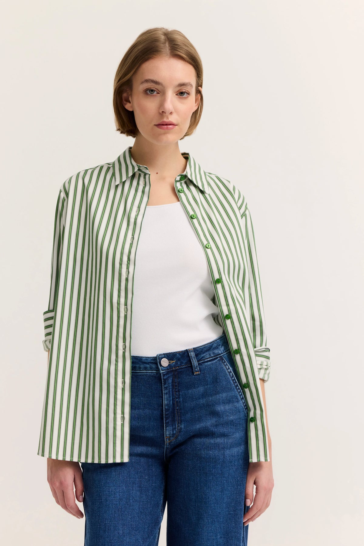 Grün-weiß gestreiftes Hemd, weißes Top, blaue Jeans