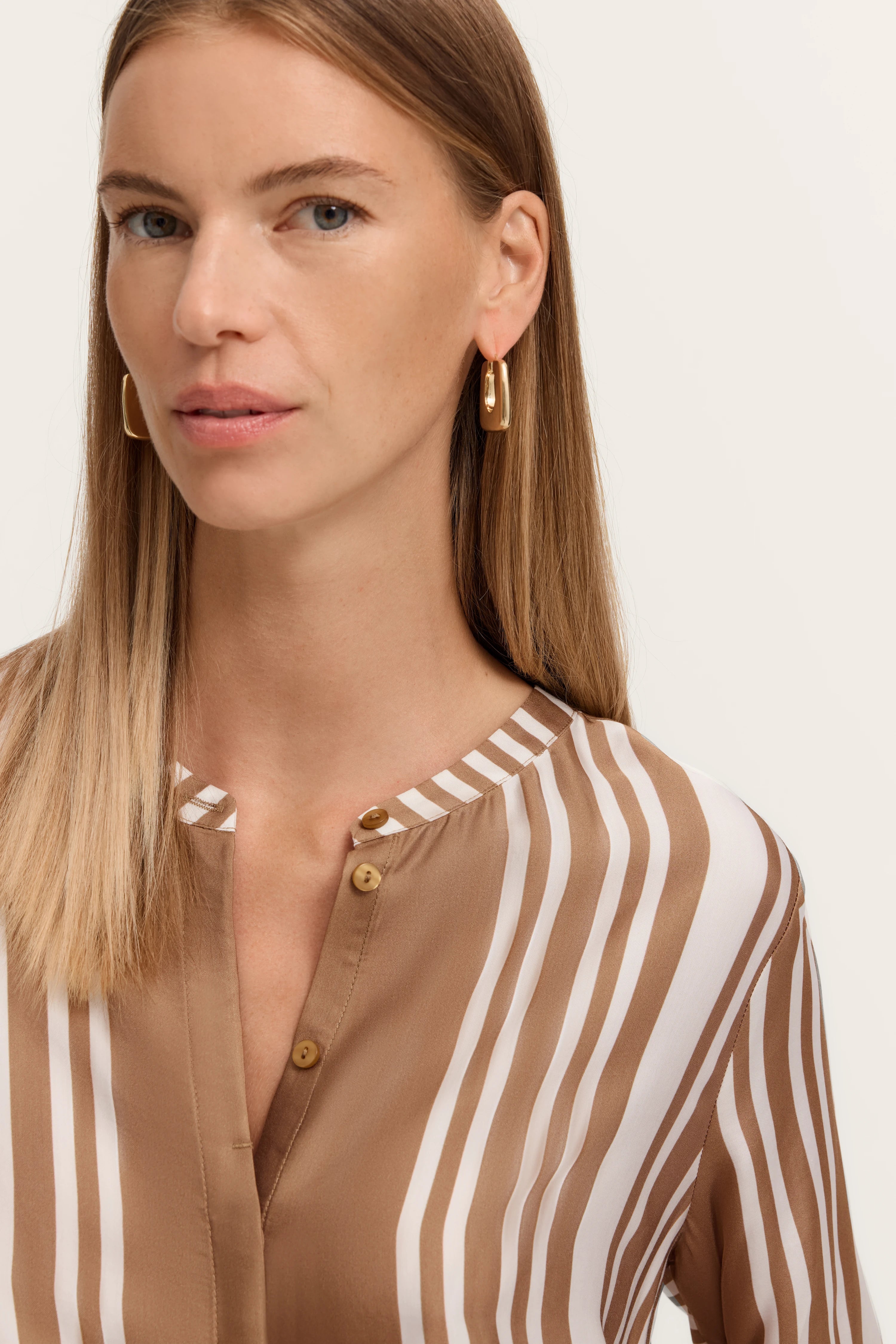 Büstenbild mit gestreifter, braun-weißer Bluse von bugatti, eleganter und stilvoller Look.