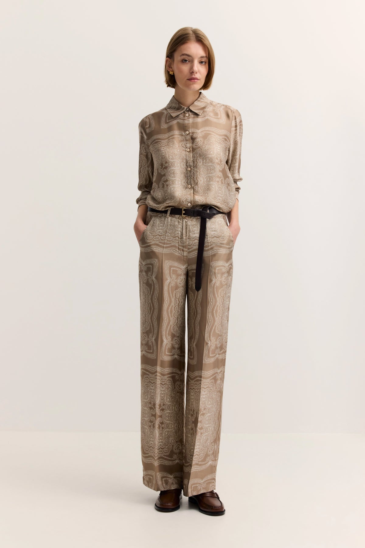 Elegantes bugatti Outfit aus beigem gemustertem Hemd und Hose, Model mit lässiger Pose.