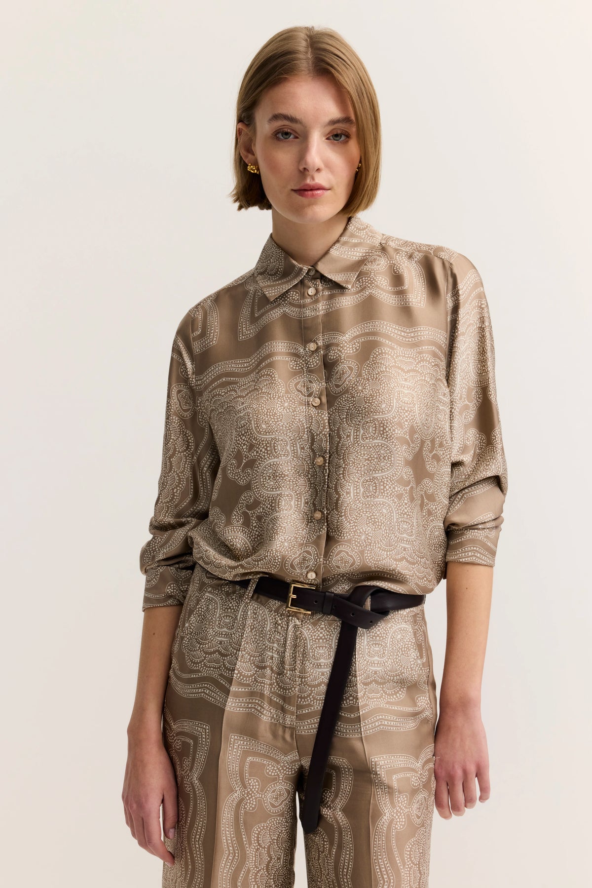 Beigefarbenes gemustertes Hemd und Hose, Modelbild, entspannte Pose, bugatti Stil.
