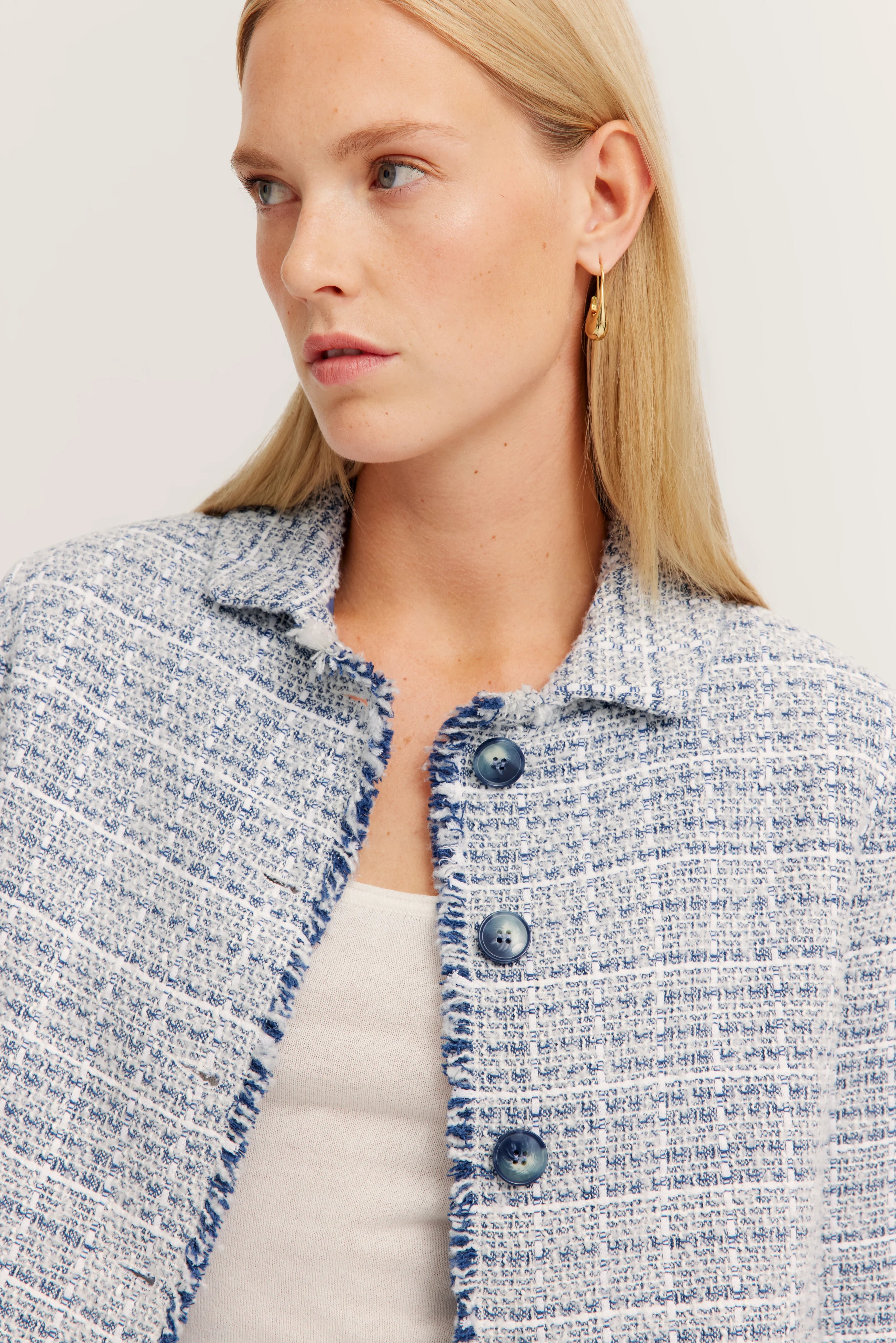 Rückansicht einer tweedartigen Jacke, blau-weiß gemustert, legerer Stil, ohne Model.