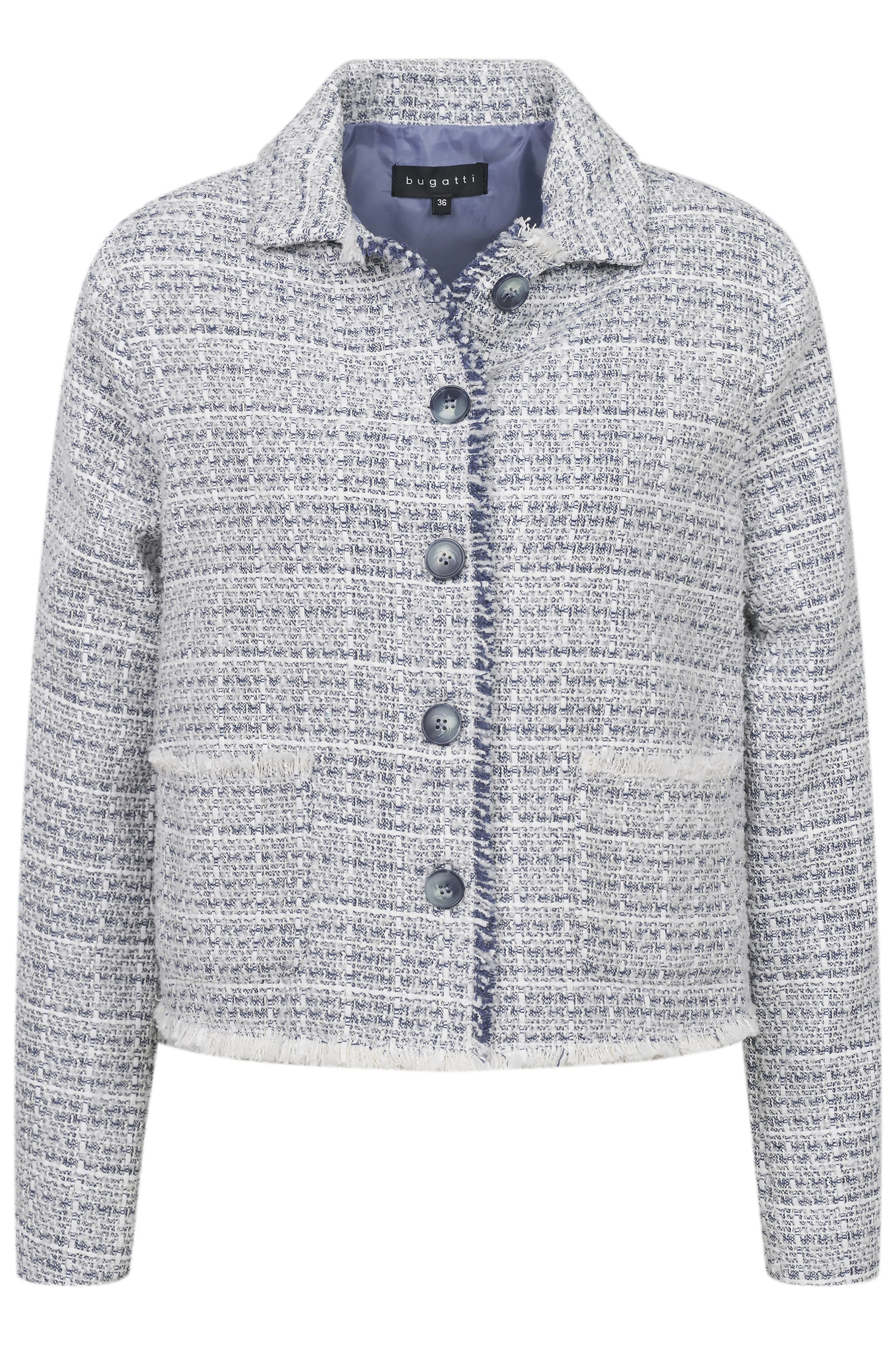 Model in blauer Tweedjacke, weißem Top, blauer Jeans, beige Schuhen. Lässig stehend, Hände in Taschen.
