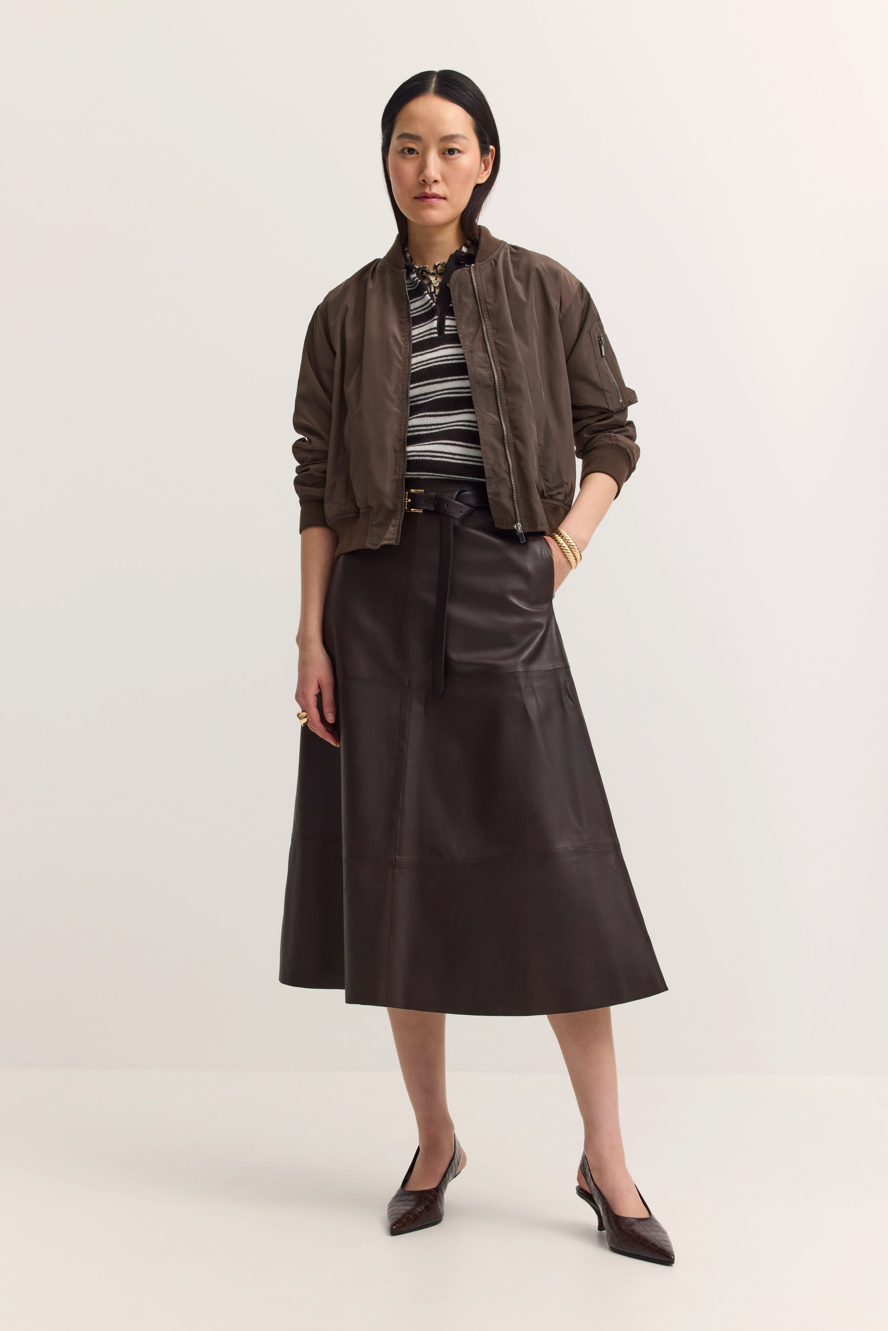 Model trägt braune Jacke, gestreiftes Shirt, braunen Rock