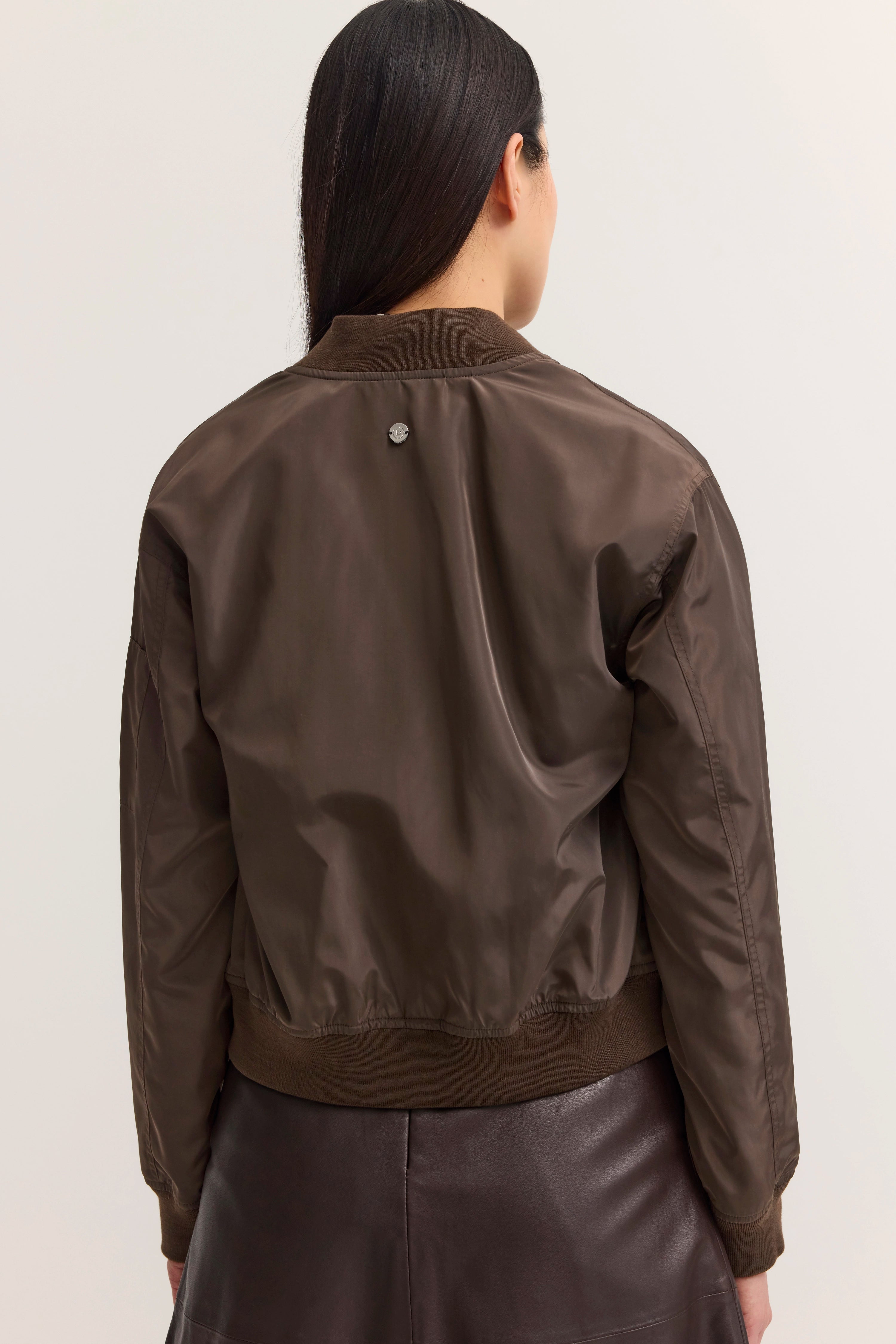 Braune bugatti Bomberjacke, Rückansicht auf Model, kombiniert mit braunem Lederrock.