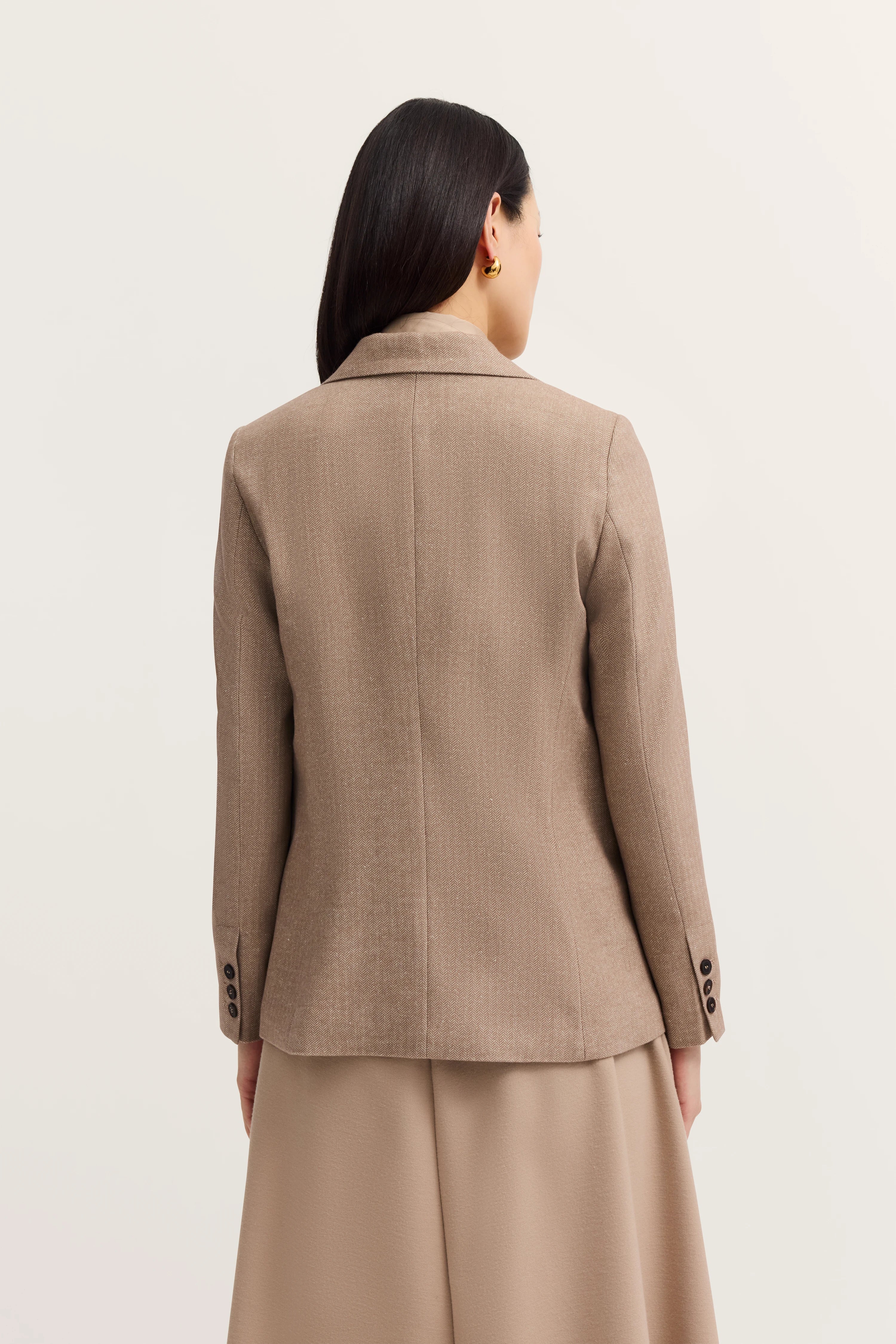 Brown blazer and skirt on model from behind, casual pose, bugatti style.