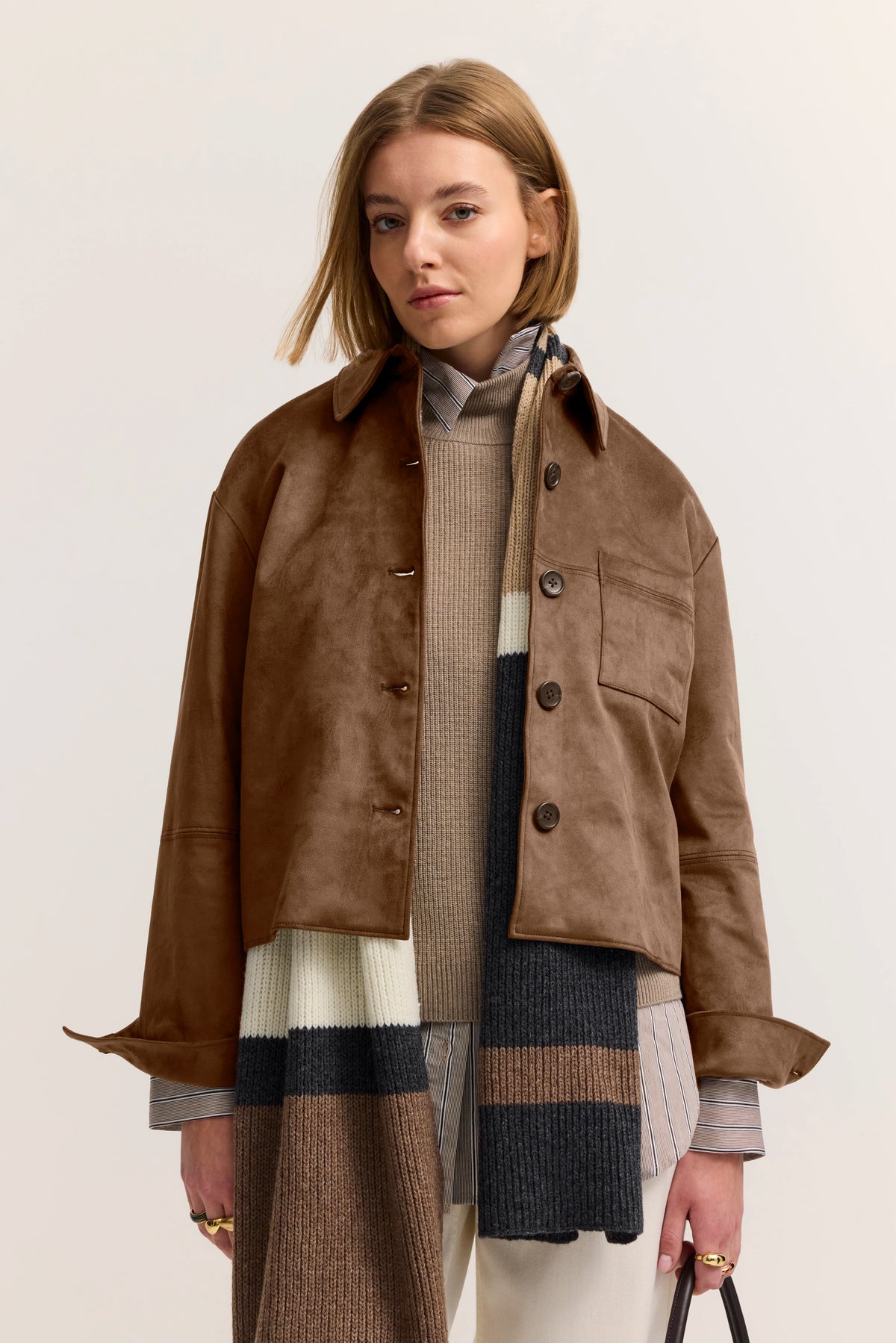 Braune Jacke mit Strickschal in Beige und Dunkelblau, Modelbild mit entspanntem Posing.