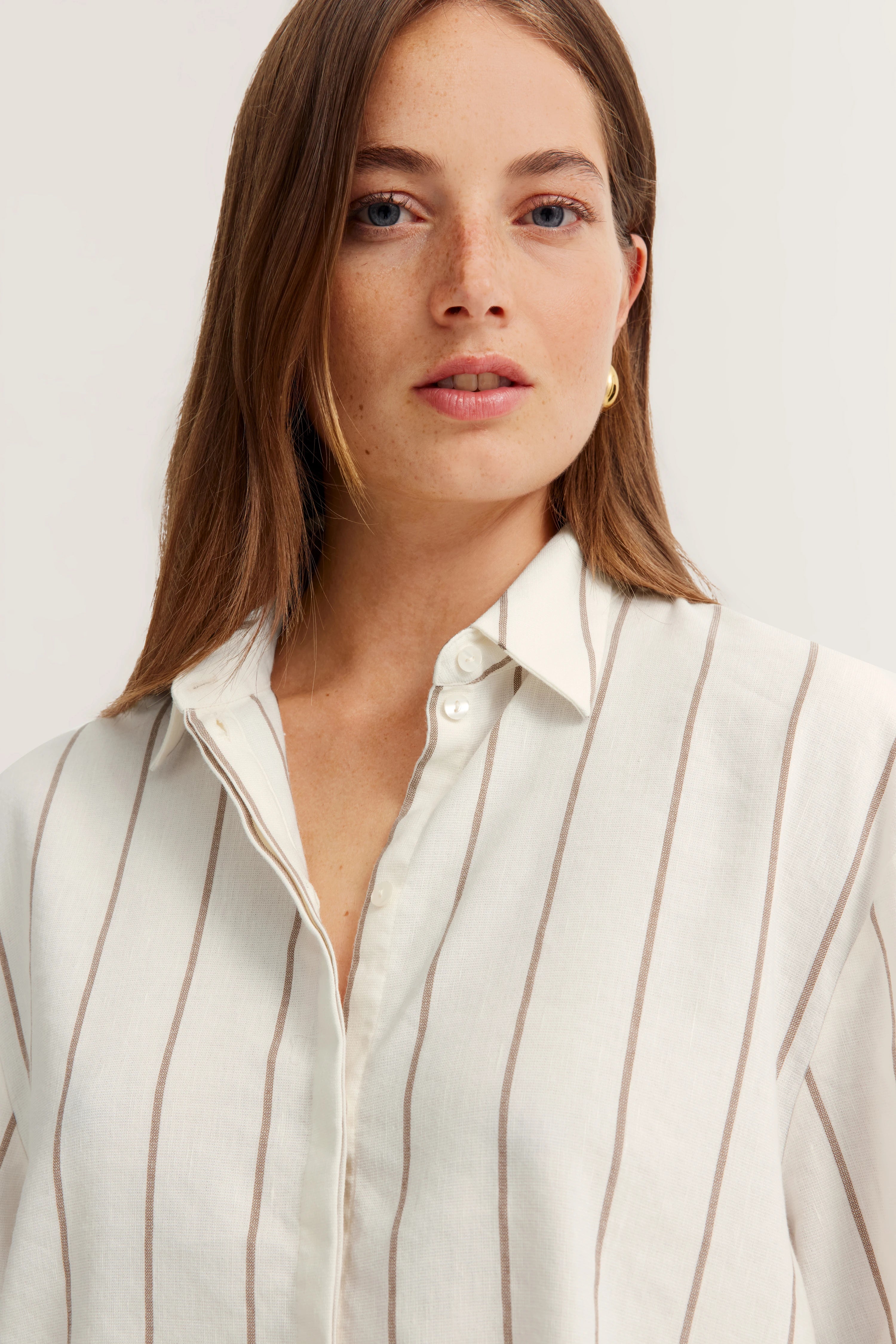 Weiße Bluse mit beigen Streifen, Modellbild, frontal, entspanntes Posing.