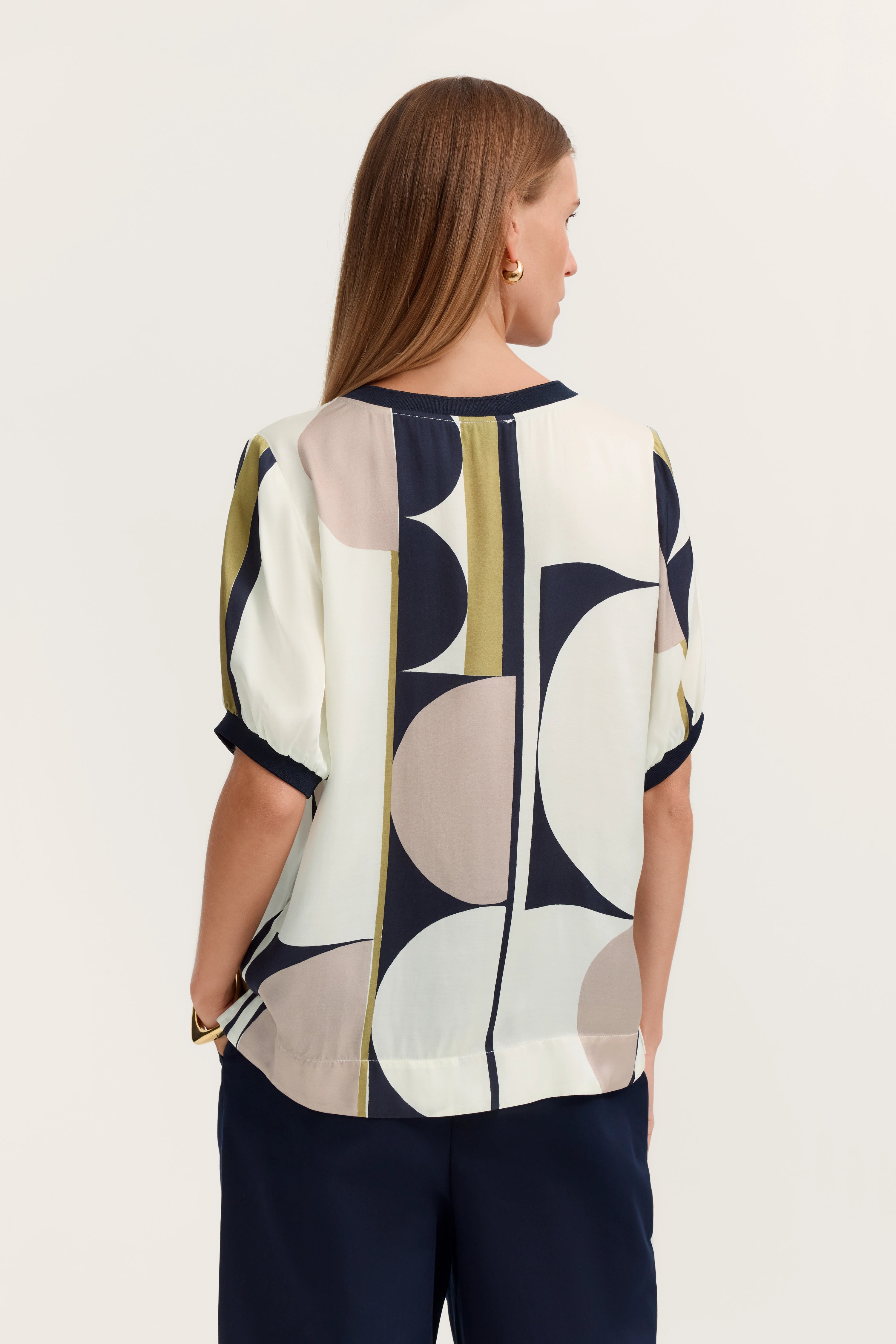 Bluse mit geometrischem Muster in Beige, Navy und Oliv. Modelbild, Rückansicht.