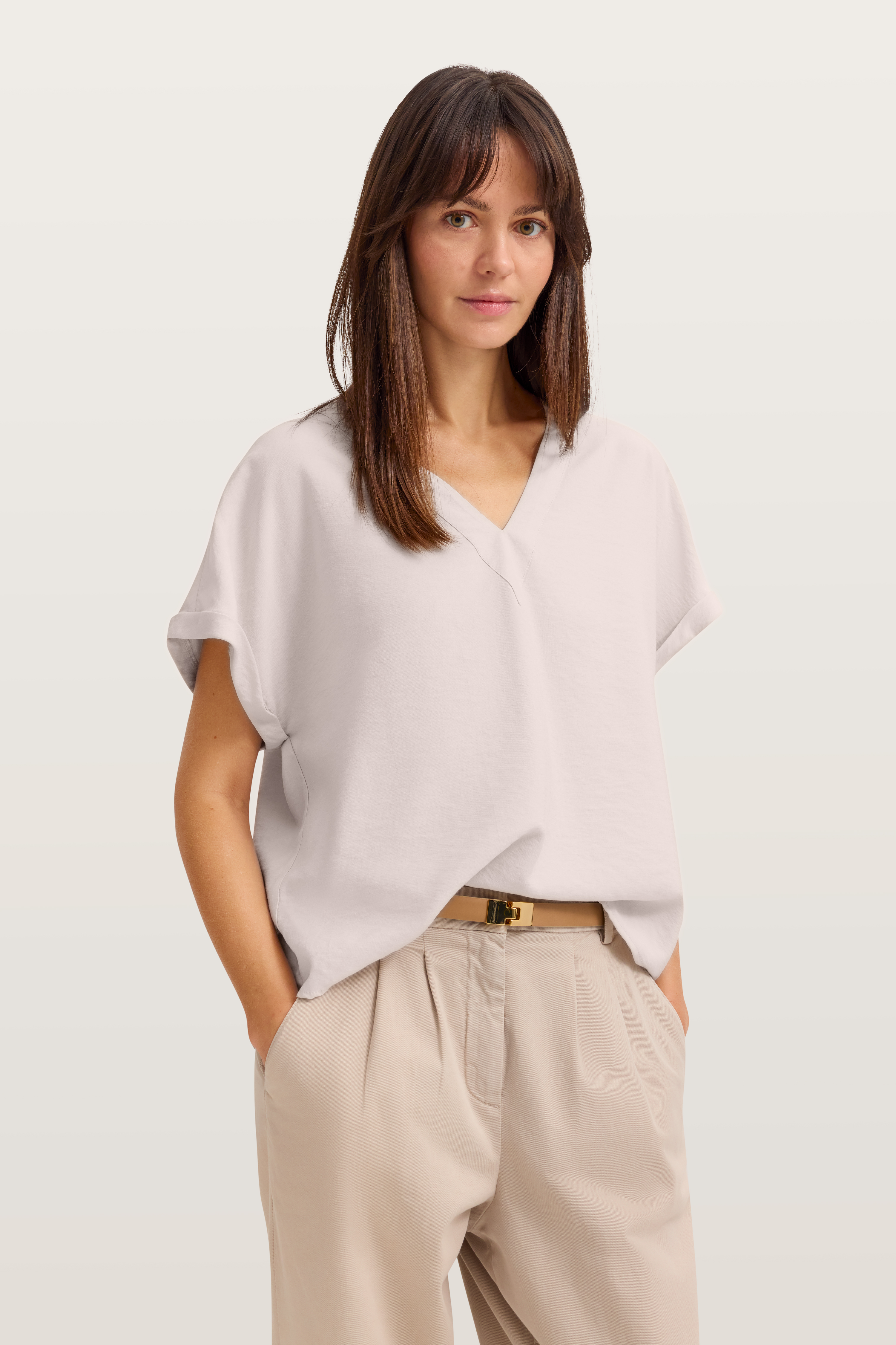 Weiße Bluse mit V-Ausschnitt und beige Hose