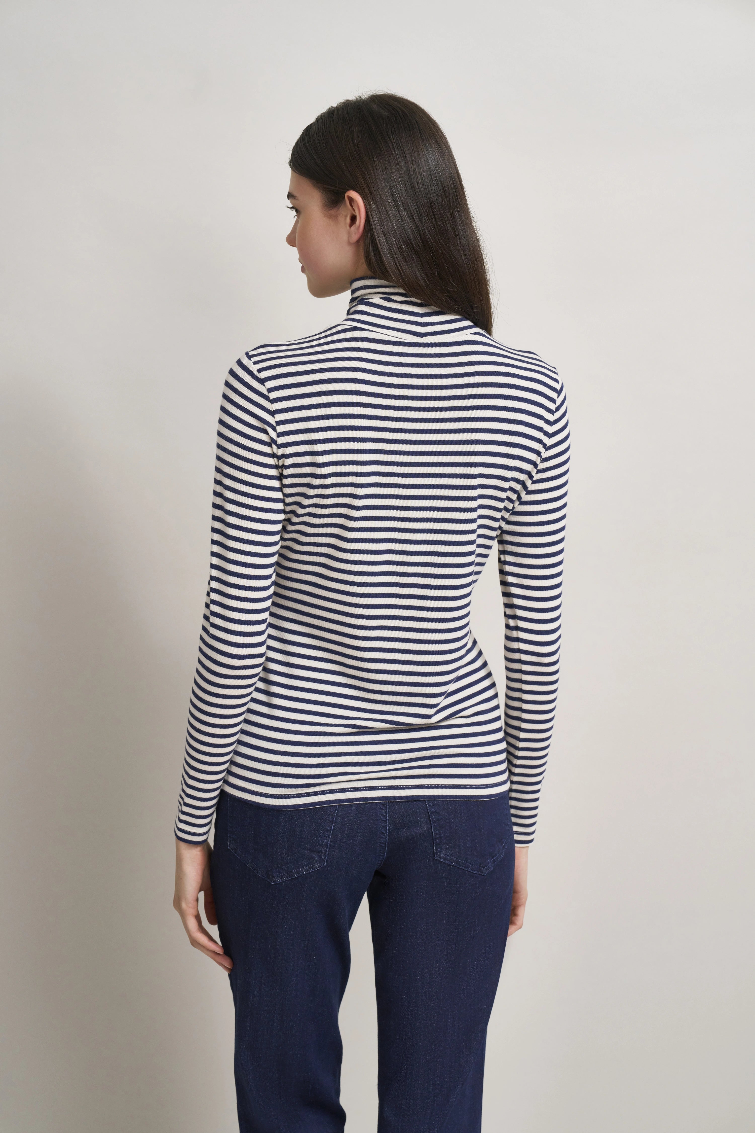 Streifenpullover in Blau-Weiß, Rückansicht, getragen von Model, kombiniert mit dunkler Jeans.