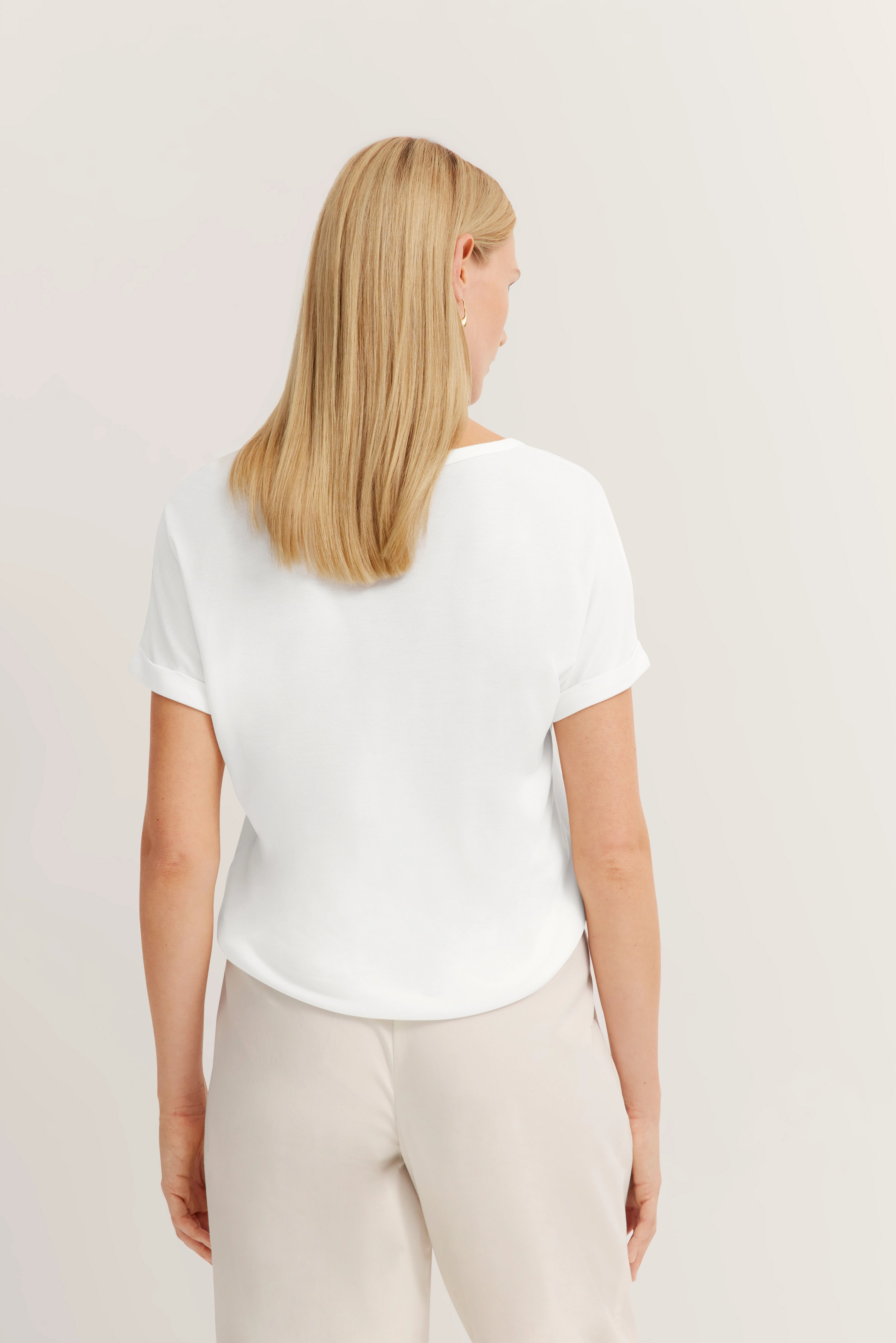Weiße Bluse und beige Hose von bugatti, Rückansicht, legeres Modelbild.