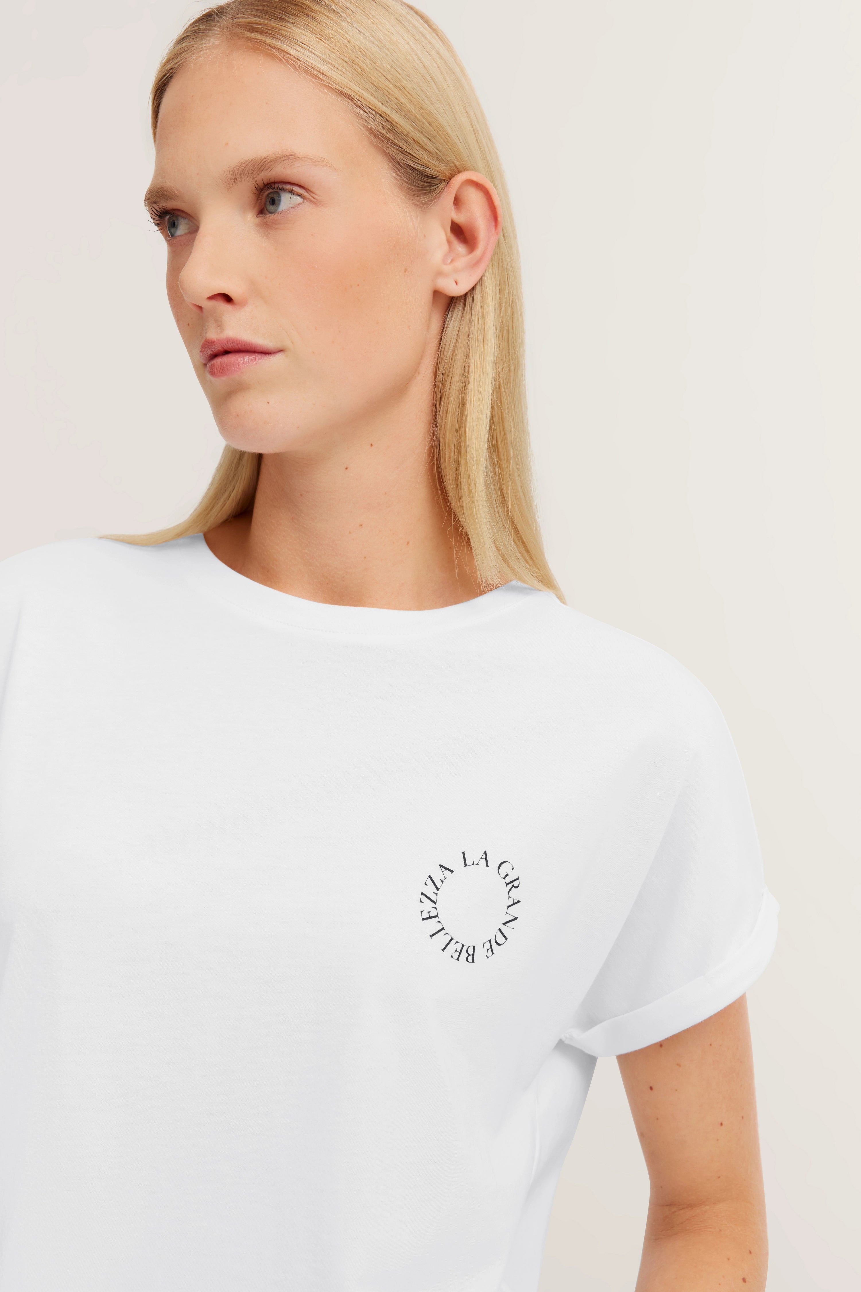 Weißes T-Shirt mit Schriftzug, Modellbild, entspanntes Posing, bugatti Stil.