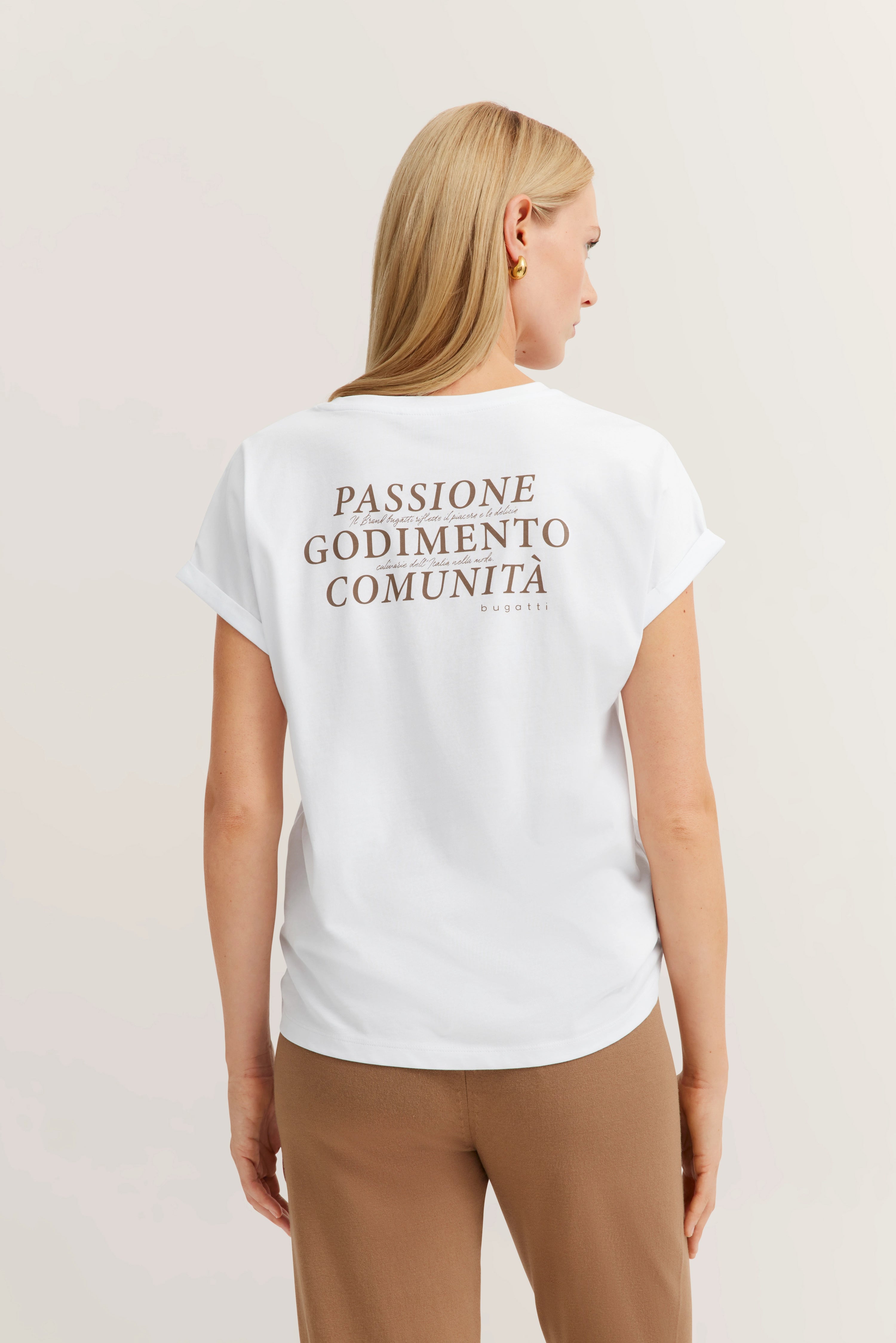 Weißes bugatti T-Shirt mit braunem Schriftzug, kombiniert mit braunen Hosen. Model von hinten.