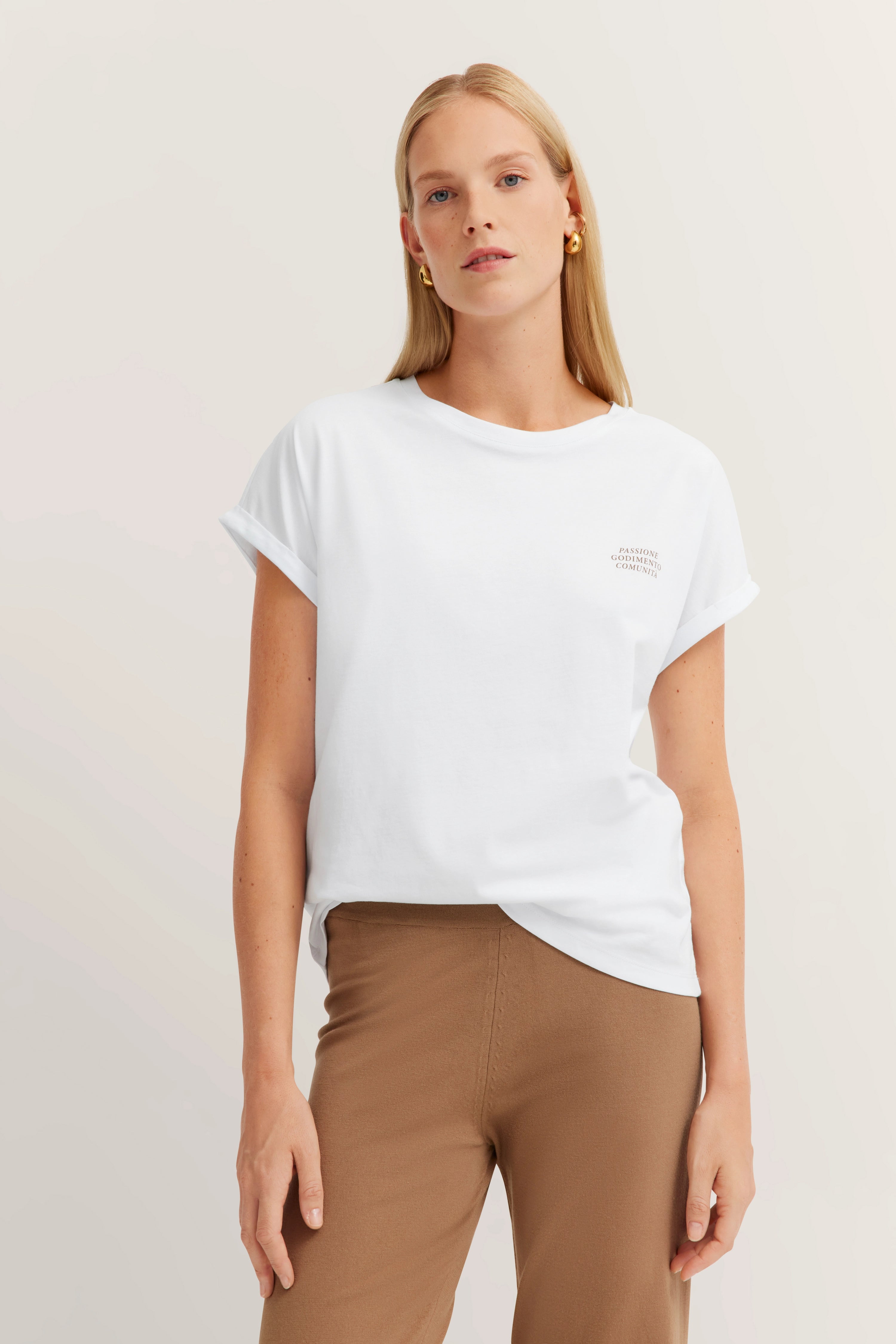 Weißes T-Shirt und braune Hose, Modelbild mit entspanntem Posing.