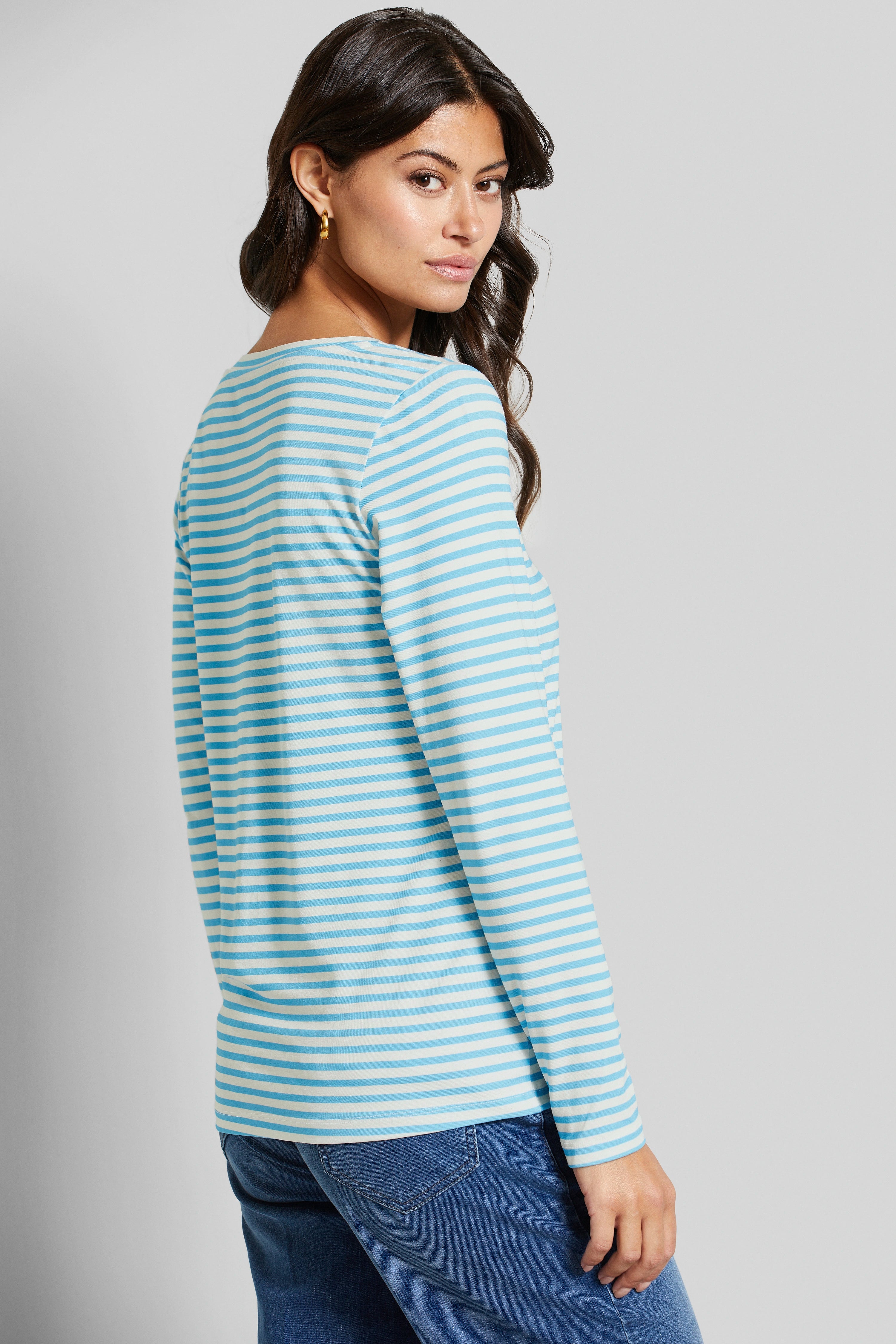 Langarmshirt met blauwe strepen, modelpose ontspannen, gecombineerd met jeansblauw.