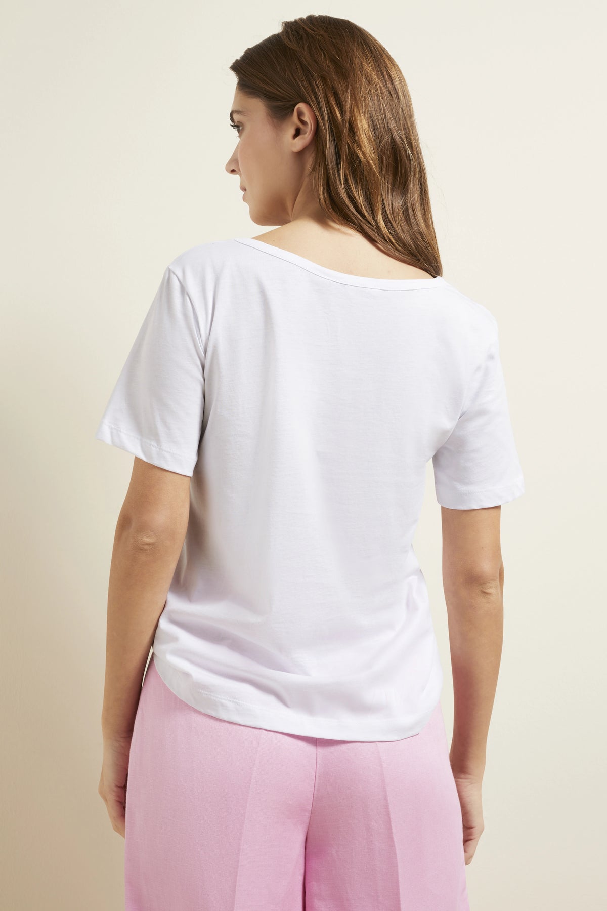 Weißes T-Shirt und rosa Hose, Model von hinten.