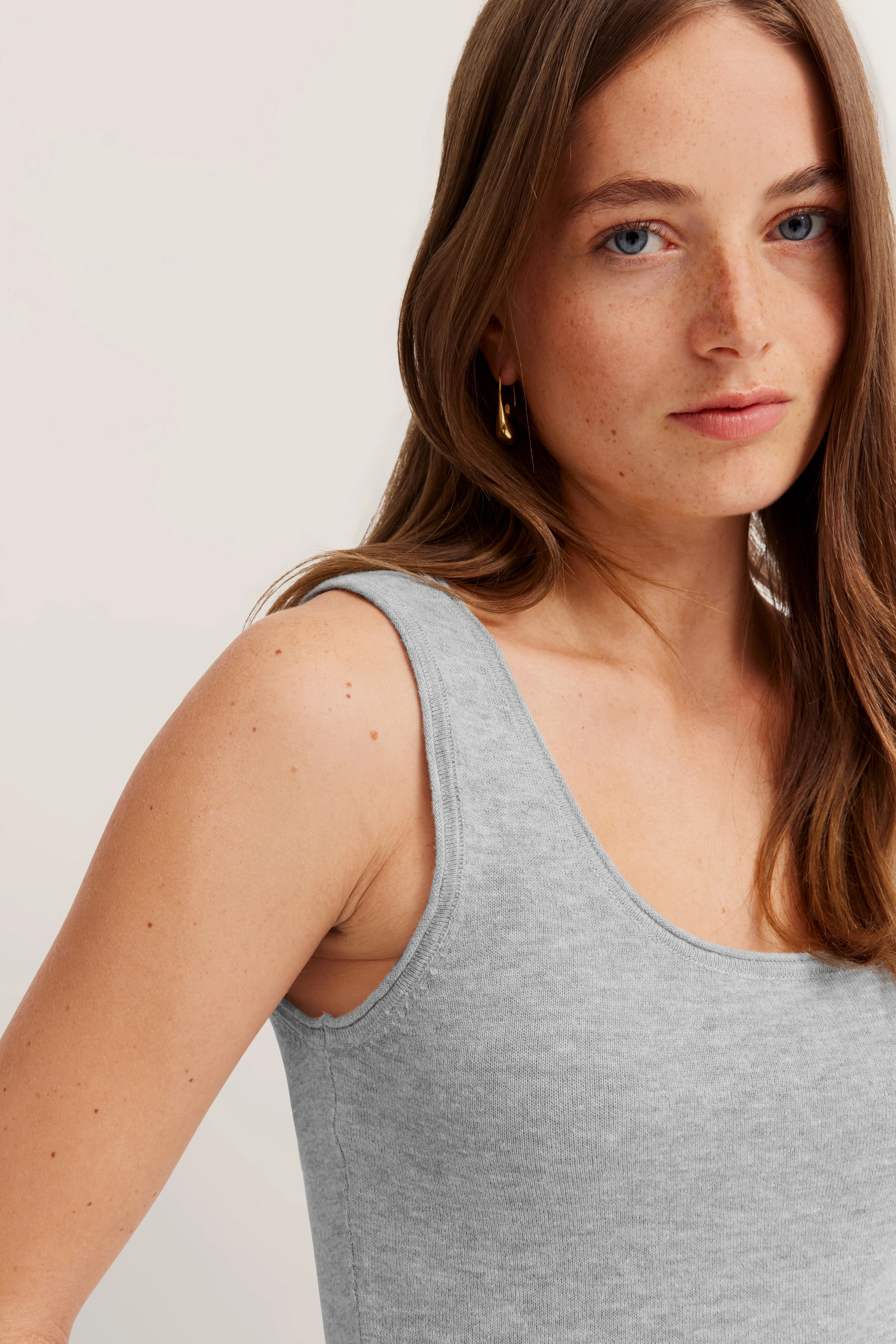 Graues ärmelloses Top, Modelbild, Kopf und Schulteransicht, entspanntes Posing.