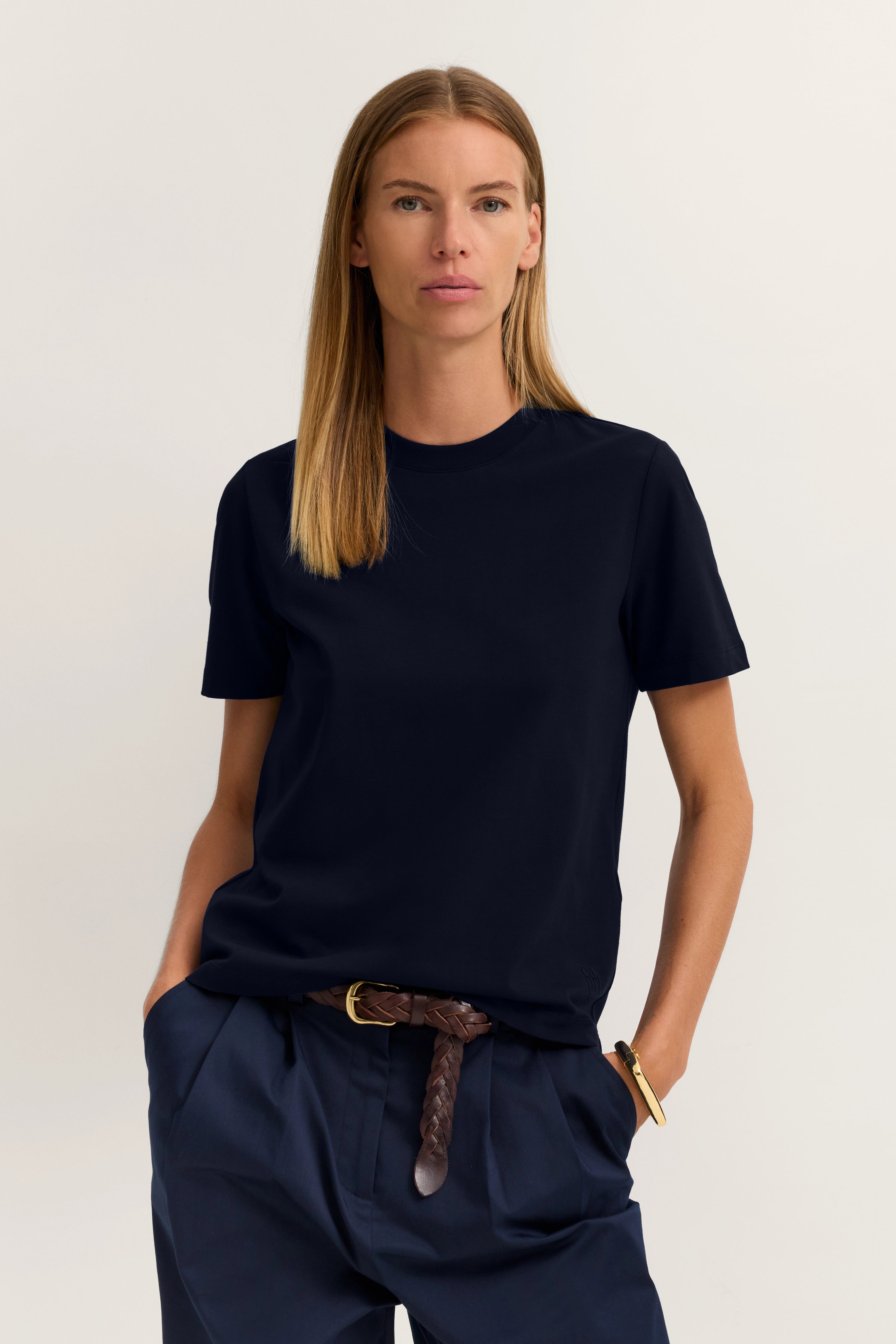 Model in navy T-Shirt und Hose von bugatti. Legeres Posing, Hände in den Hosentaschen.