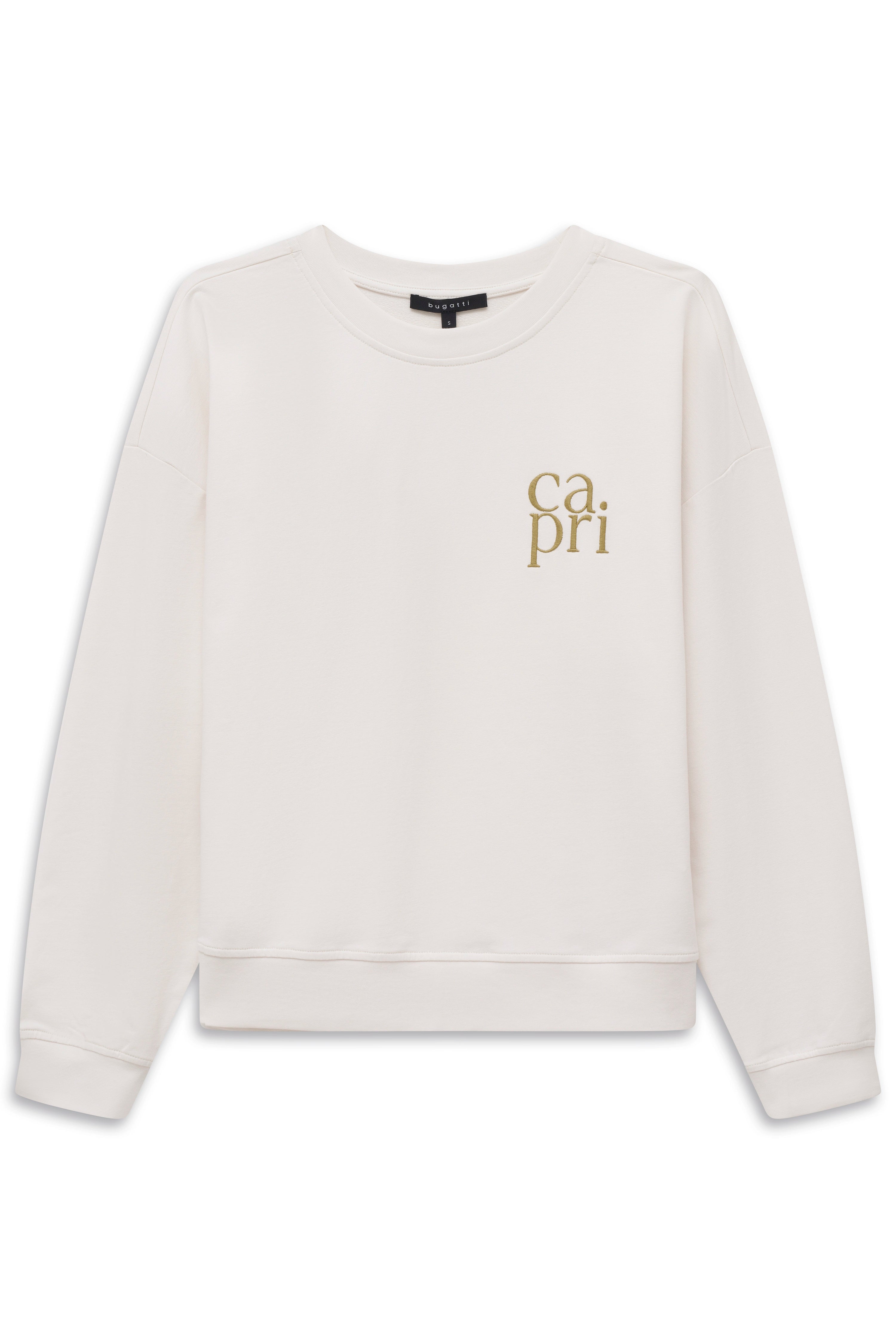 Model in cremefarbenem Pullover und beigen Hosen von hinten. Legeres Bild, entspannte Pose.