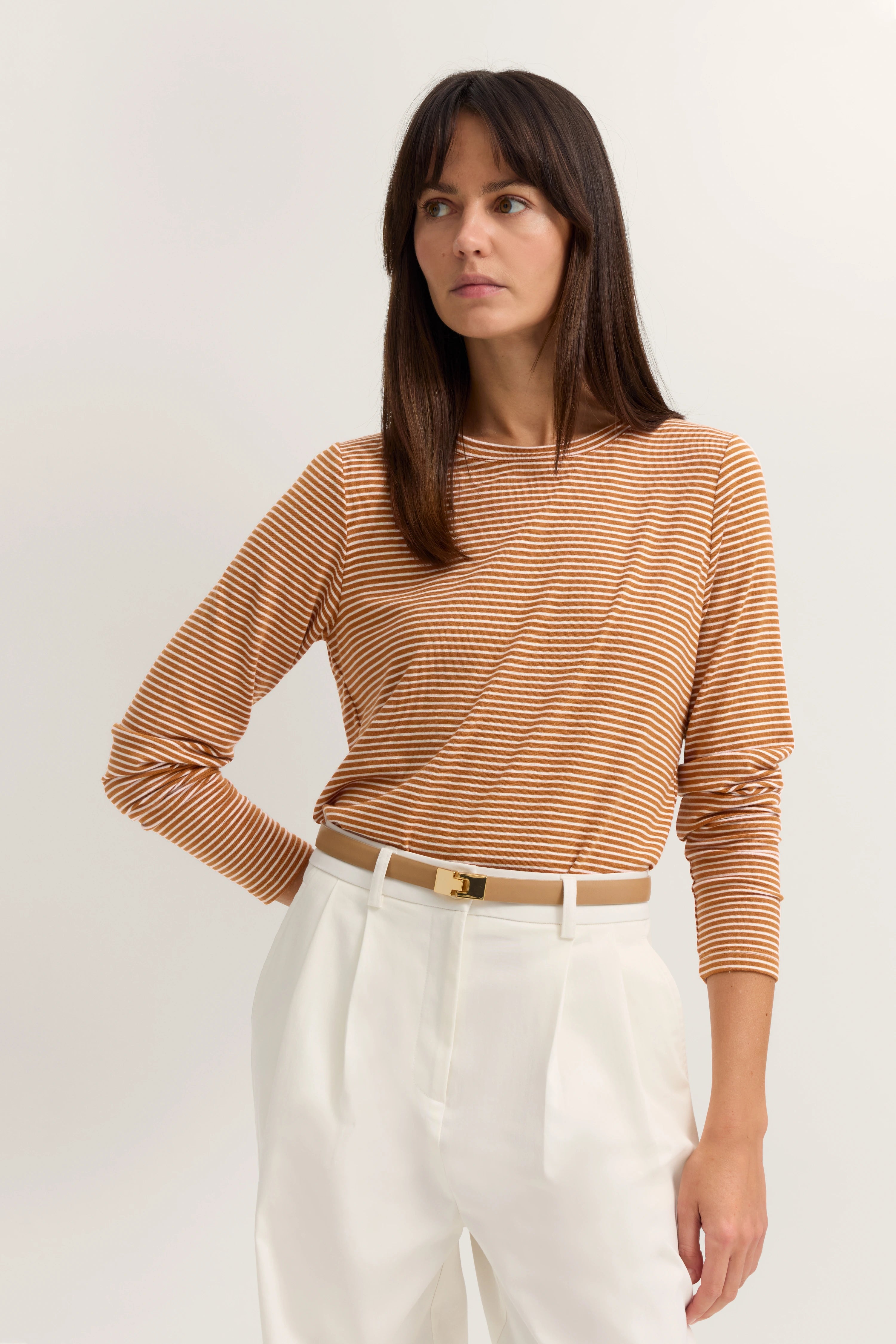 Streifen-Shirt in braun-weiß und weiße Hose, Model posiert mit Blick zur Seite, bugatti Stil.