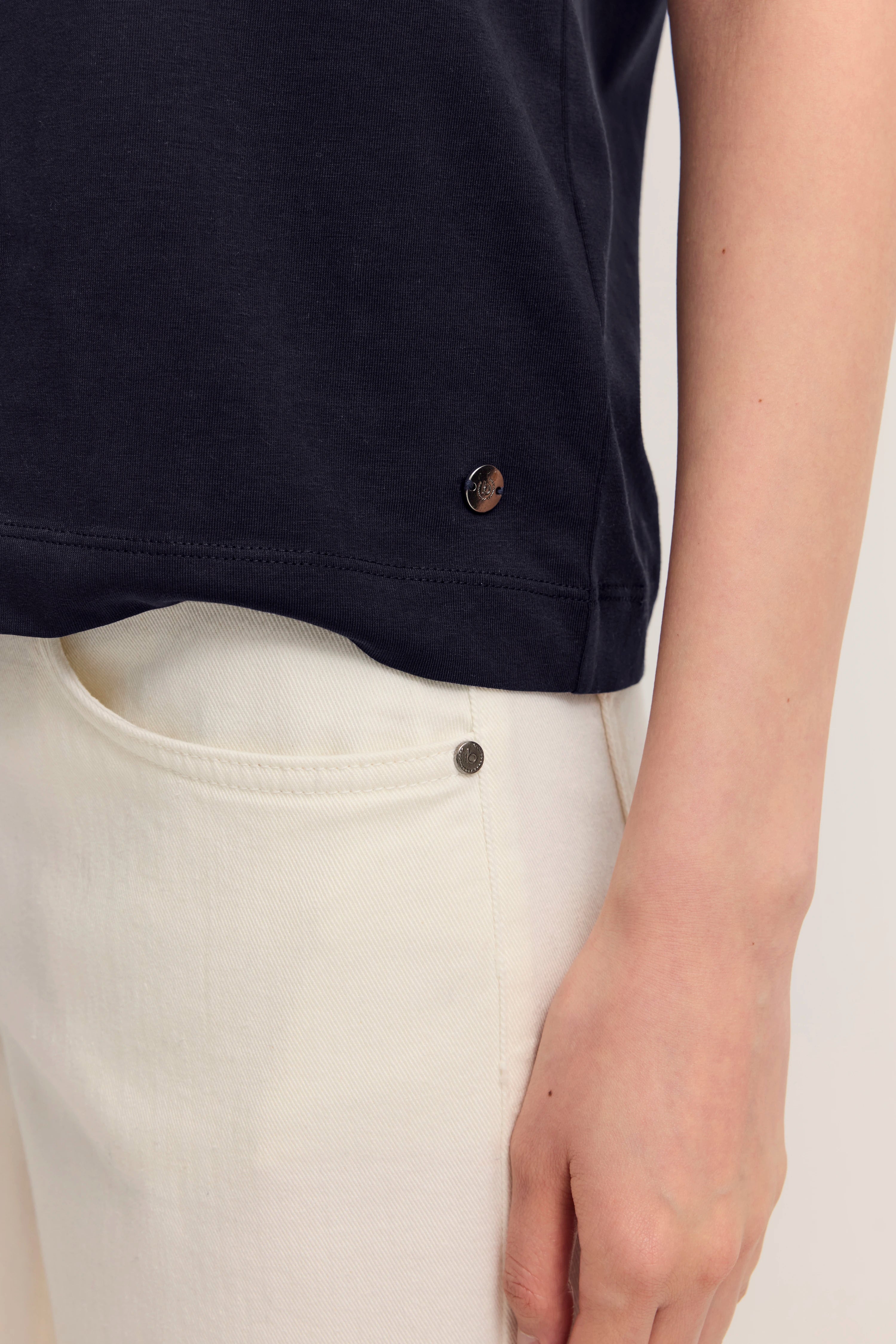 Navy T-Shirt mit weißer Jeans, Detailaufnahme, bugatti Stil.