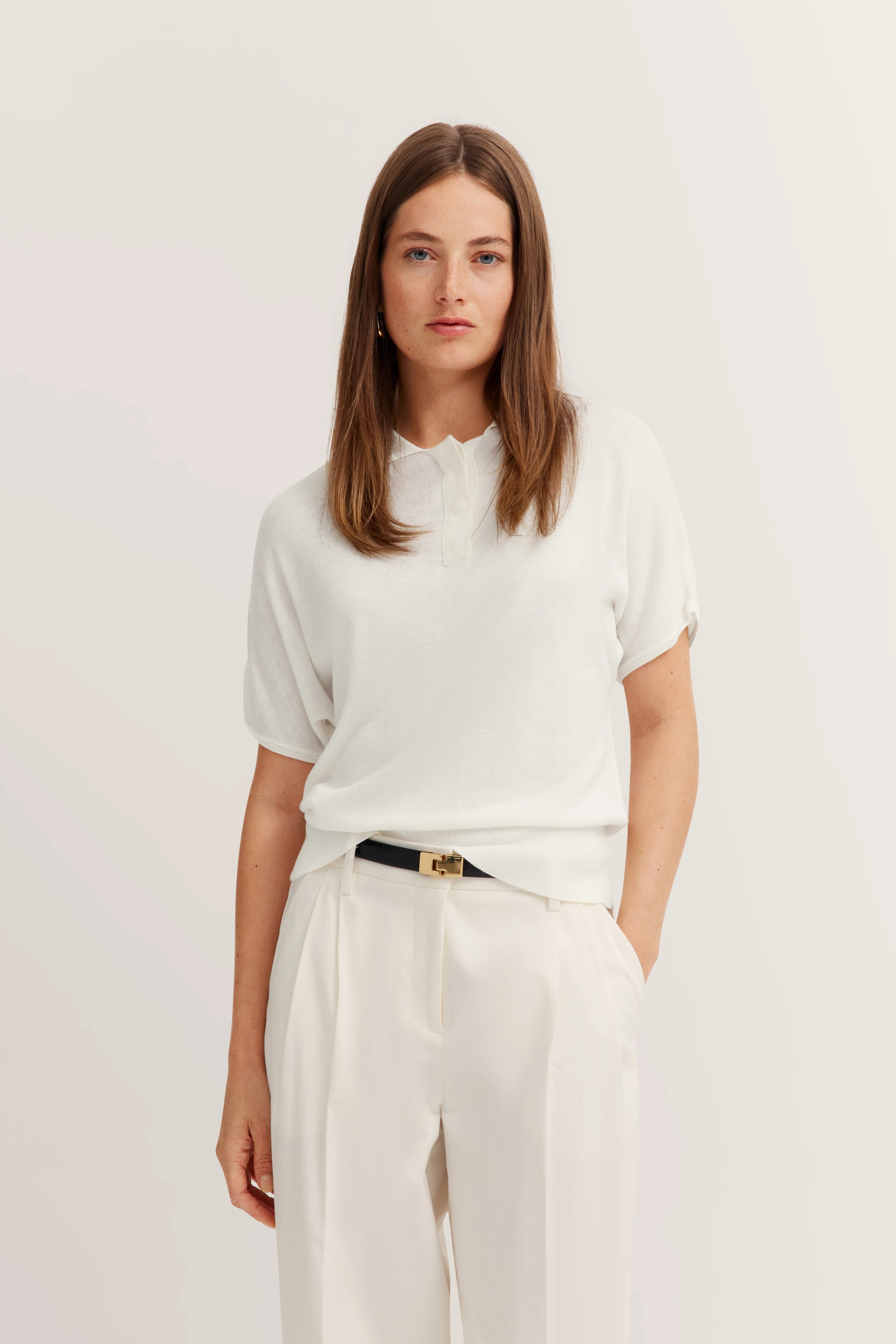 Weiße Bluse und Hose, legeres Modelbild, stehende Pose, bugatti Stil und Eleganz.