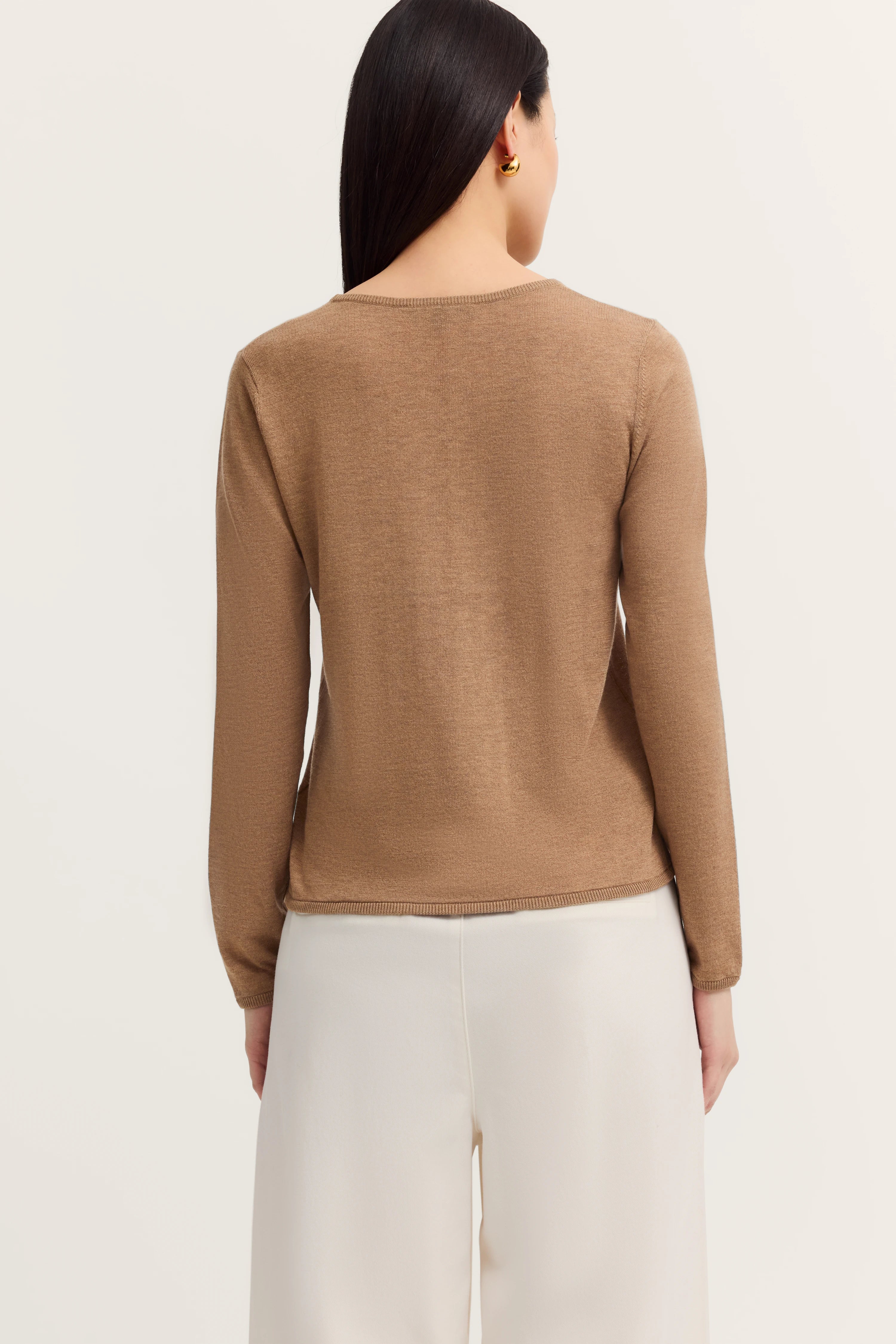 Brauner Pullover von bugatti, Modellbild von hinten, kombiniert mit weißen Hosen.