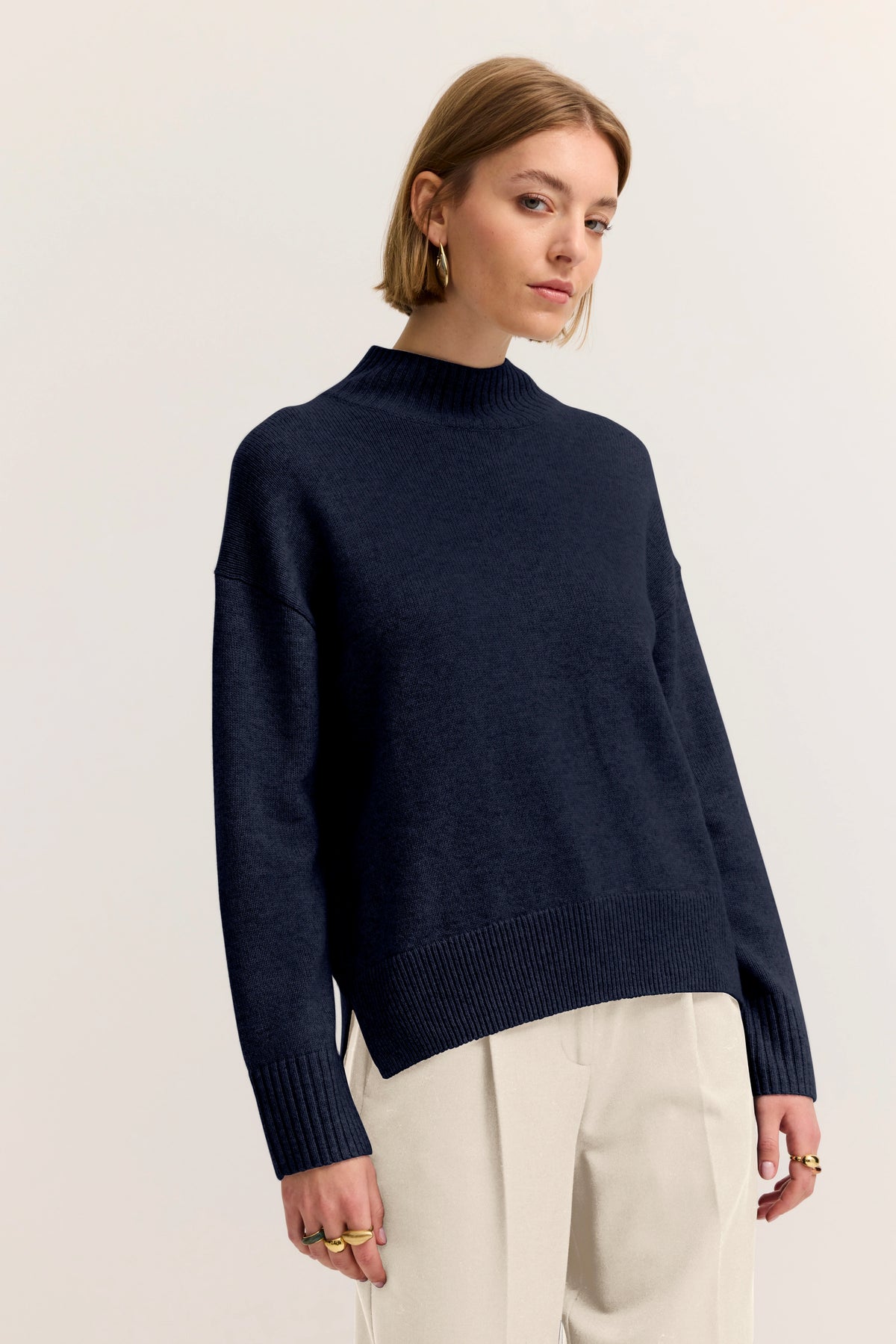 Navy Pullover und beige Hose, Model stehend, entspannte Pose, bugatti Stil.