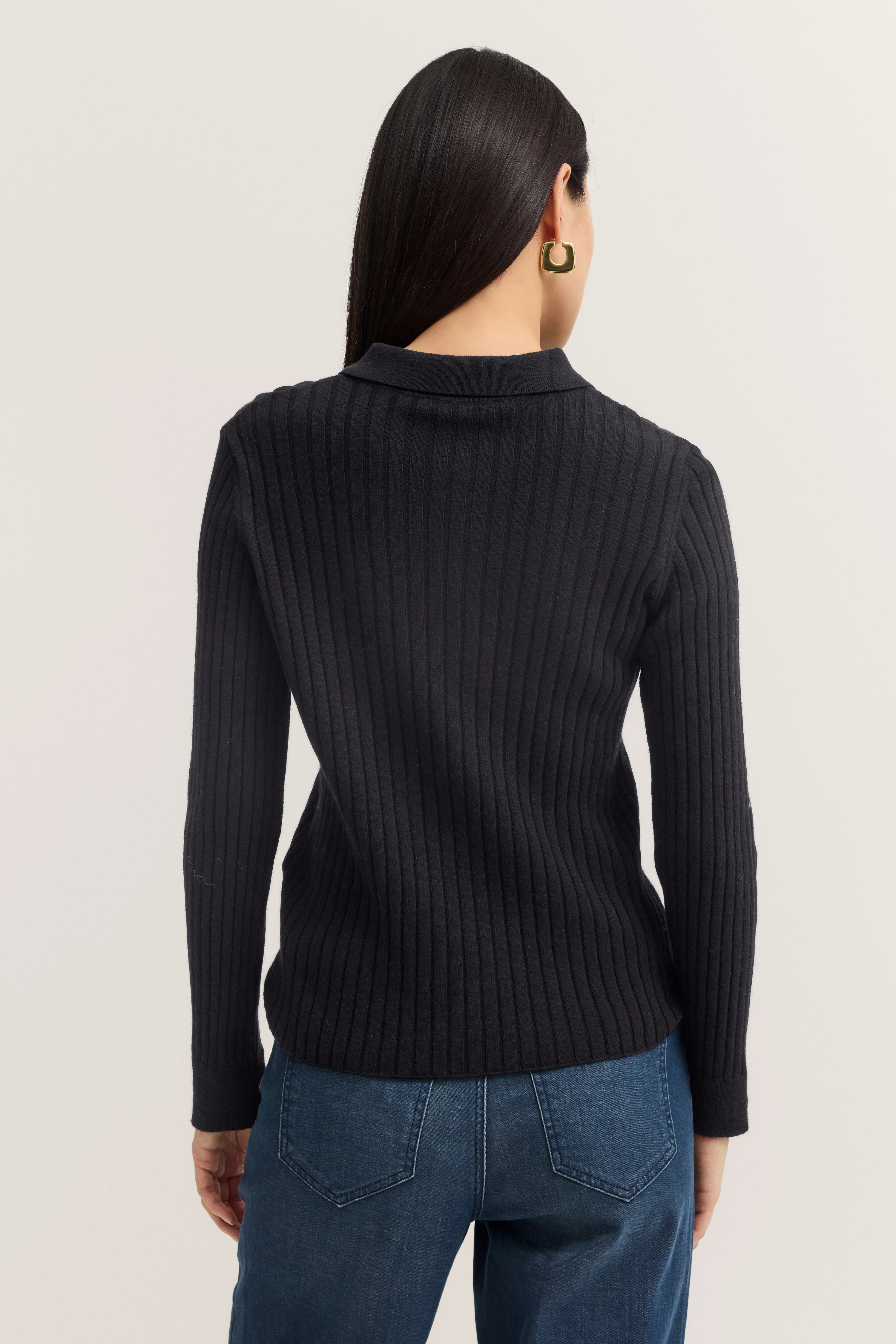 Schwarzer gerippter bugatti Pullover und blaue Jeans, Model von hinten.