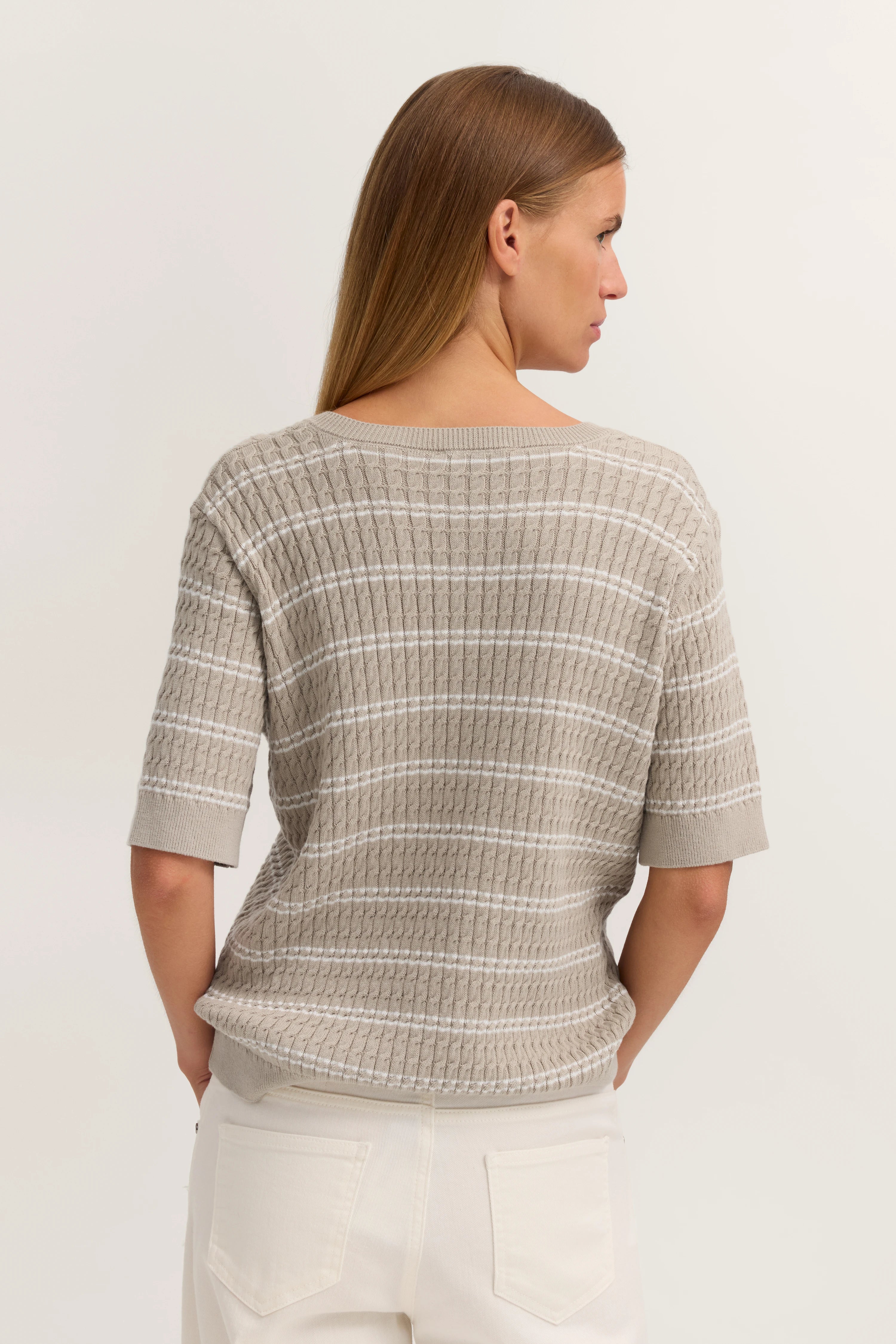 Beiger Strickpullover mit Streifenmuster, Model von hinten, Arme locker an den Seiten.