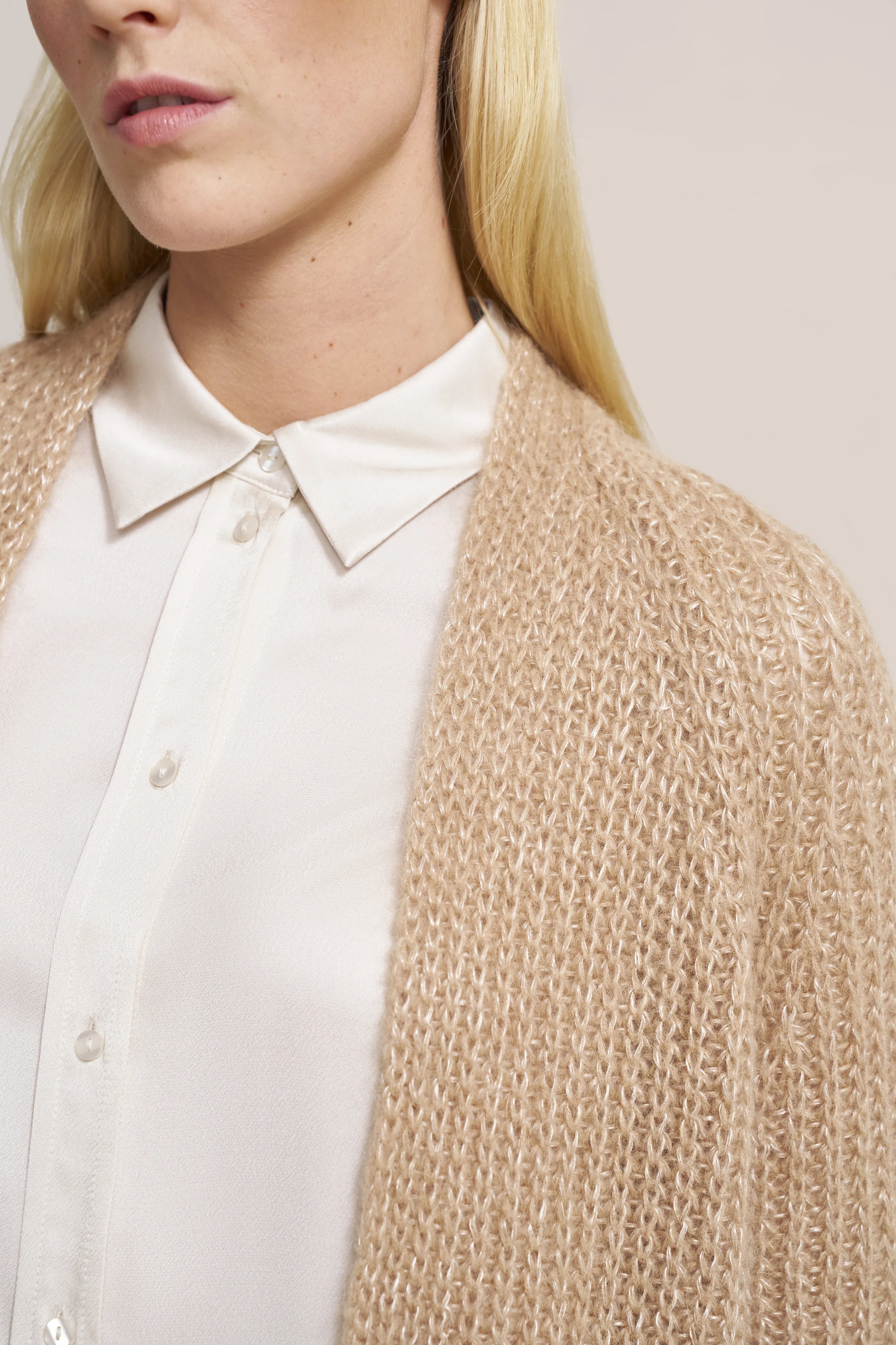 Beige Strickjacke über weißer Bluse, Büstenbild, elegant und zeitlos von bugatti.