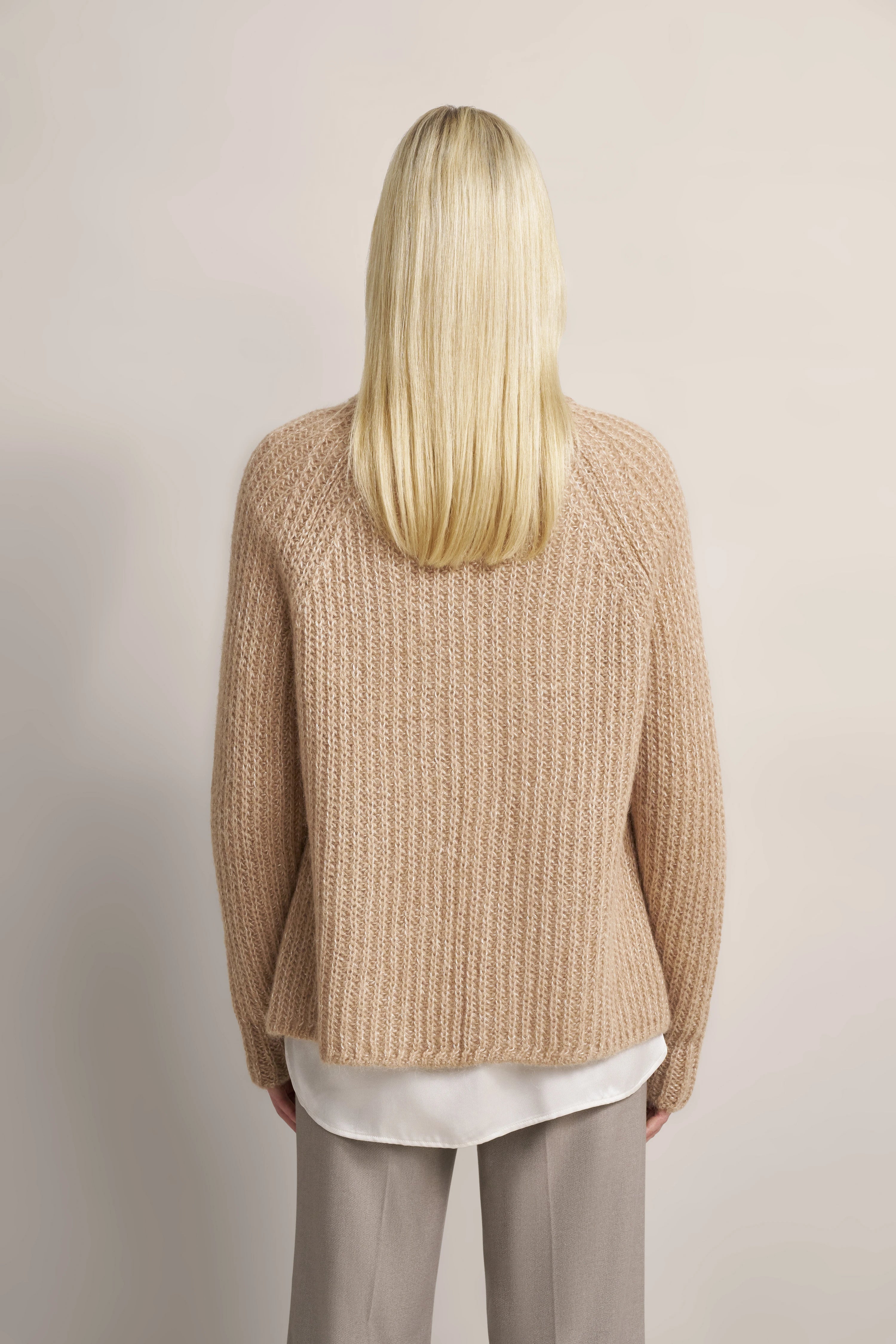 Beiger Strickpullover über weißer Bluse, graue Hose, Rückansicht, bugatti Stil und Qualität.