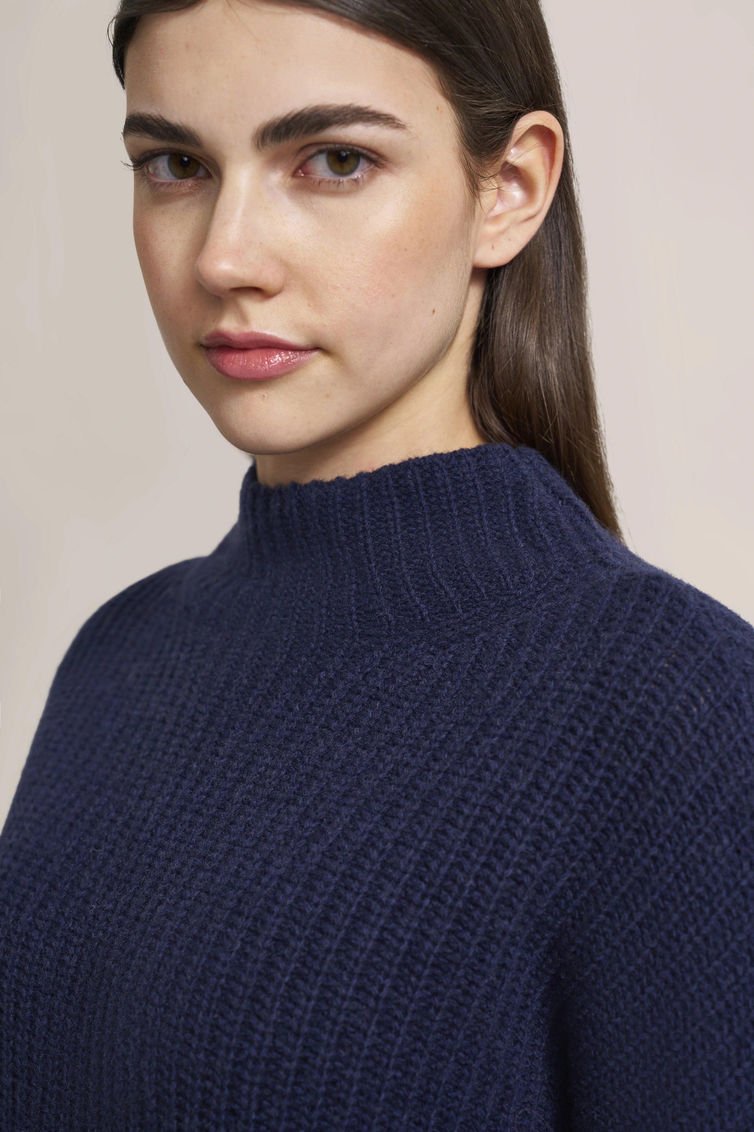 Bust shot of navy knit sweater by bugatti, simple design, high collar.